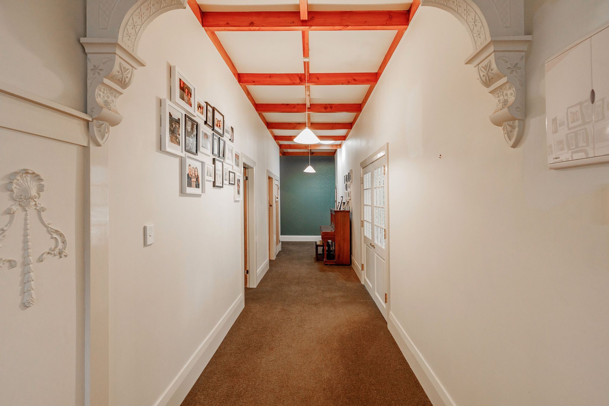 To visually elevate the space, a decorative dark blue wallpaper applied to the end of a long hallway, creates the illusion of a shorter space. Aspiring Walls - Focus Collection - Paintables - RD80027 was painted in Resene Snapshot.