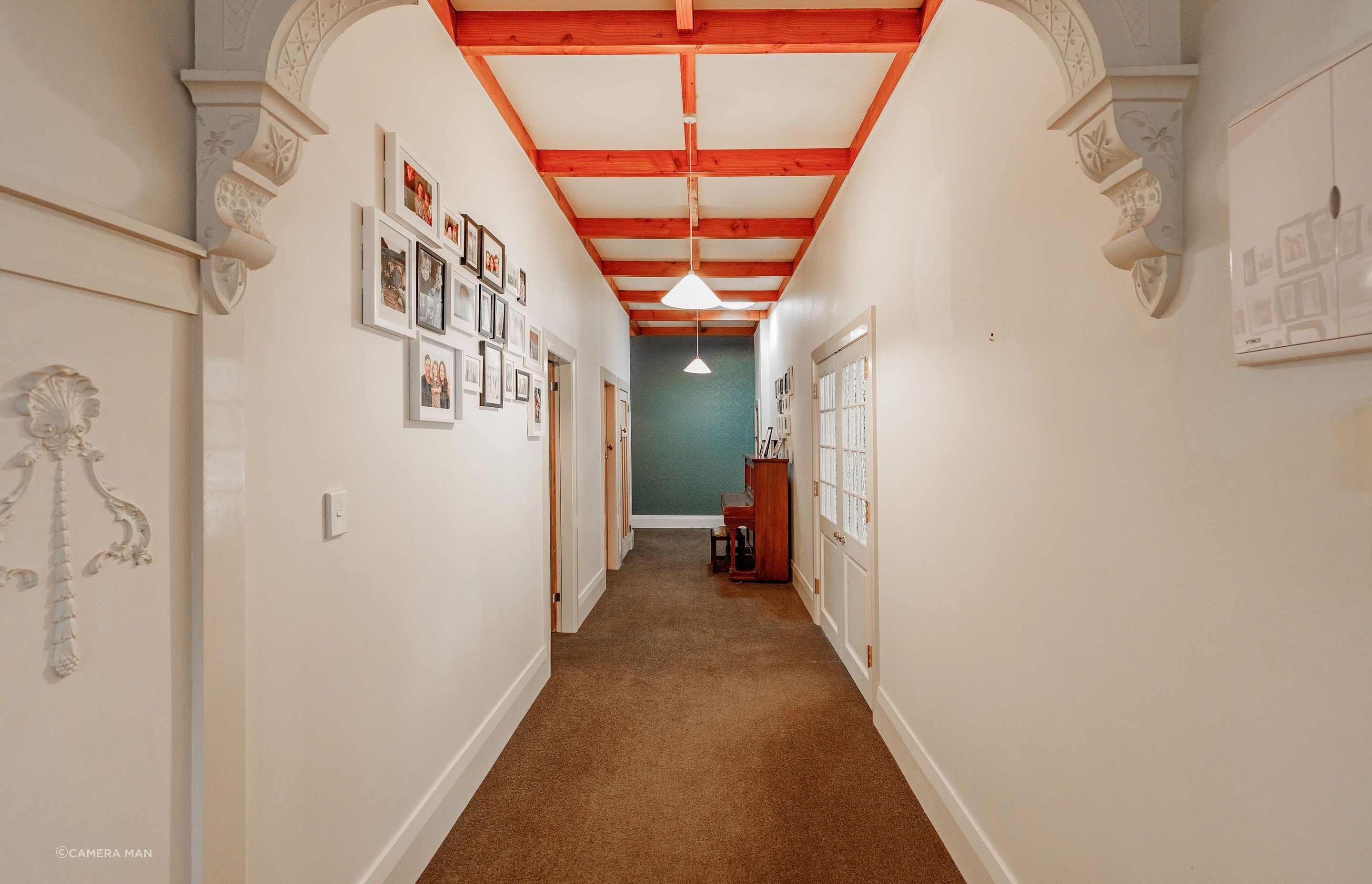 To visually elevate the space, a decorative dark blue wallpaper applied to the end of a long hallway, creates the illusion of a shorter space.  Aspiring Walls - Focus Collection - Paintables - RD80027 was painted in Resene Snapshot.