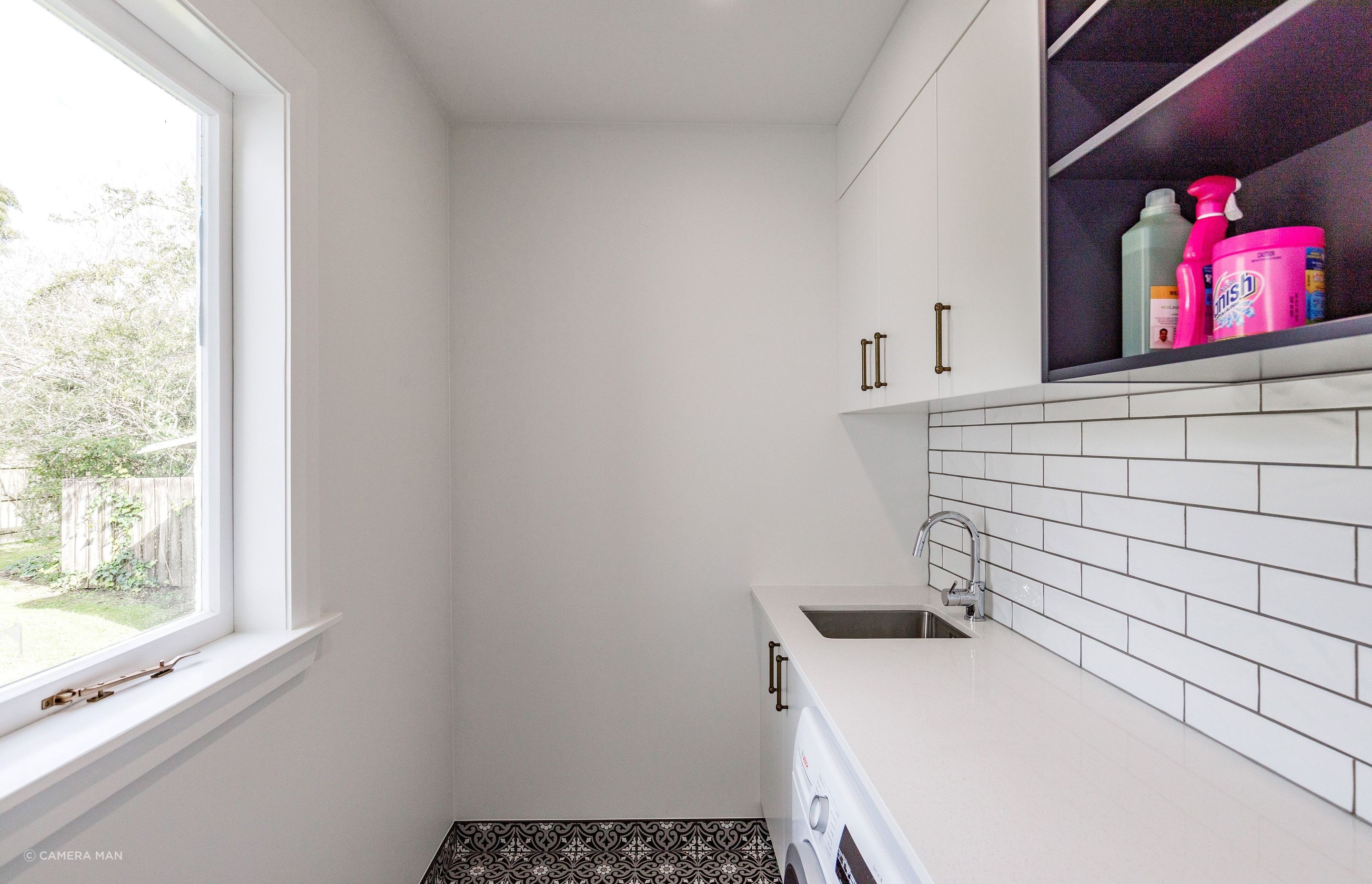 Ensuring complementary and cohesive changes to each of the spaces the laundry received cabinetry to match the kitchen finishes and handle selection. The floor tiles are Tile Warehouse - Element - Arabesque with the skirt tile Tile Warehouse -Pure Black Matt to mirror the en-suite. The textured subway tiles used for the splash-back are Tile Space - MT1366 - Marlow Cloud Gloss.