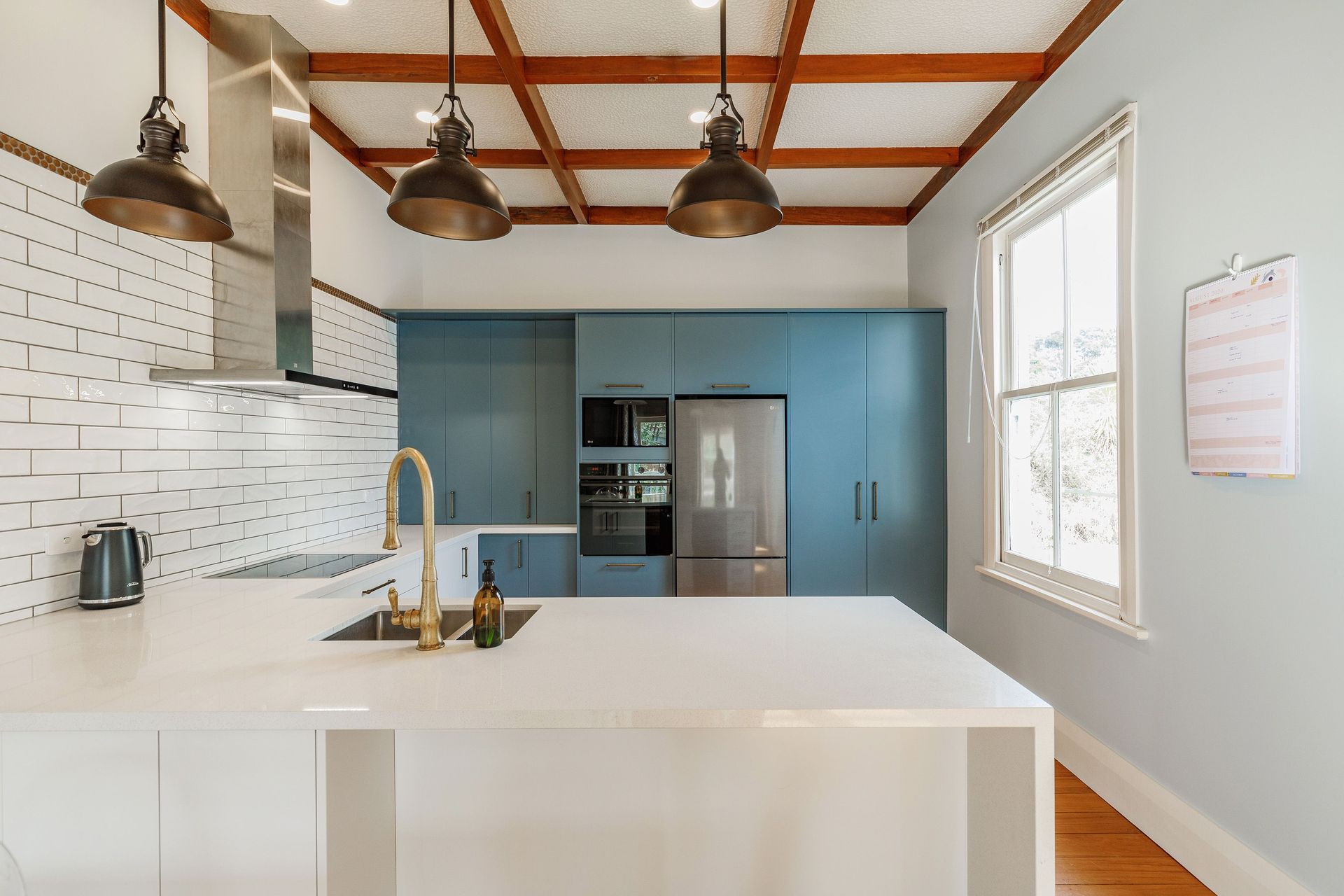 The kitchen boasts  new benchtop - Smartsone_Santorini Collection_Gelsomino new handles - Stefano Orlatti_3440 Matt Antique Brass new sink mixer - Plumbline_Classic Kitchen Mixer with pull-out Spary new cabinet fronts in Melteca Warm White &amp; Winter Sky Naturale All are complemented by a splash-back of textured glazed subway tiles and bronze button mosaics. Industrial-style light fittings add a contemporary edge.