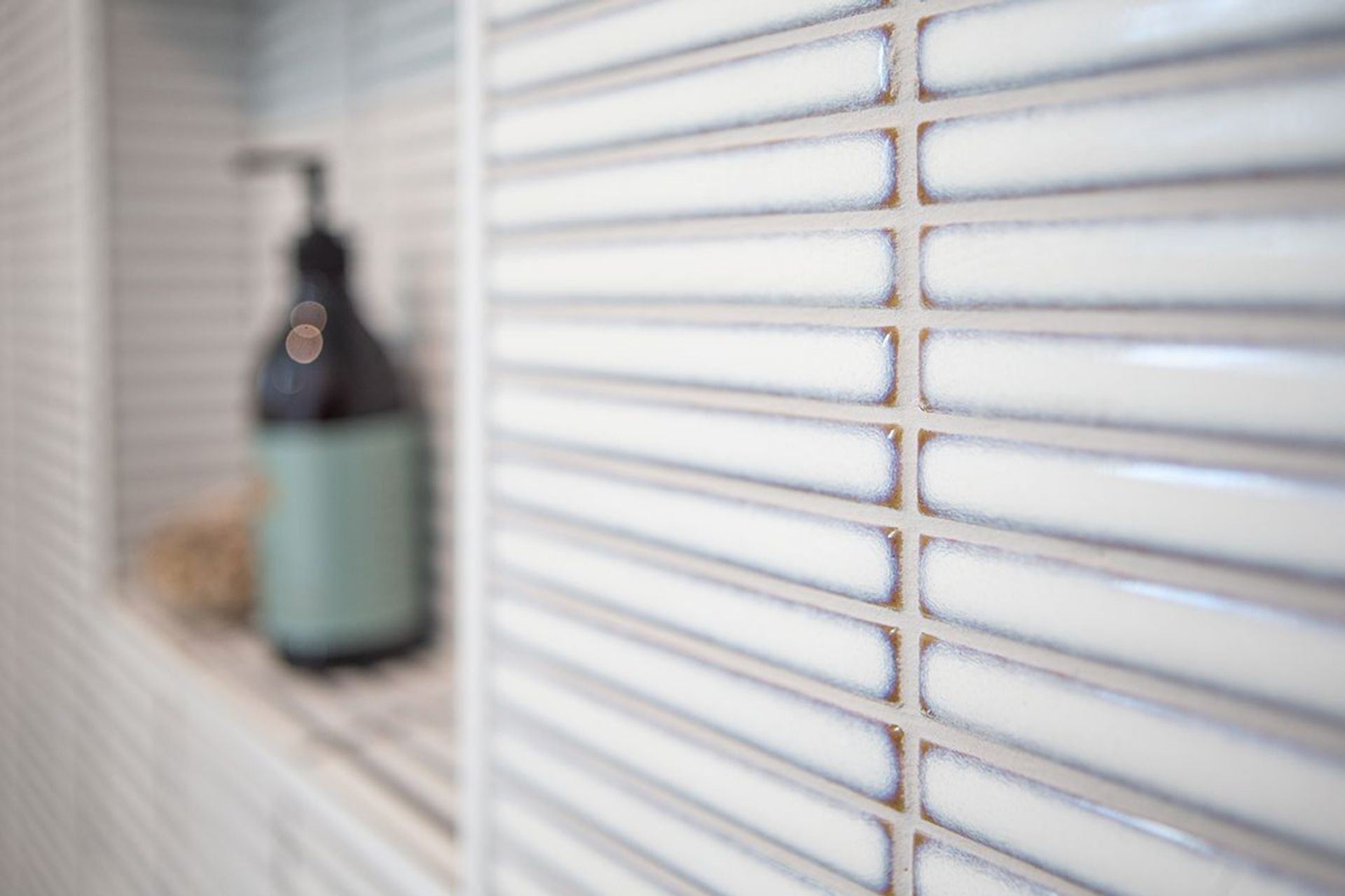 Horizontally laid finger mosaic add some colour and texture to the shower area.