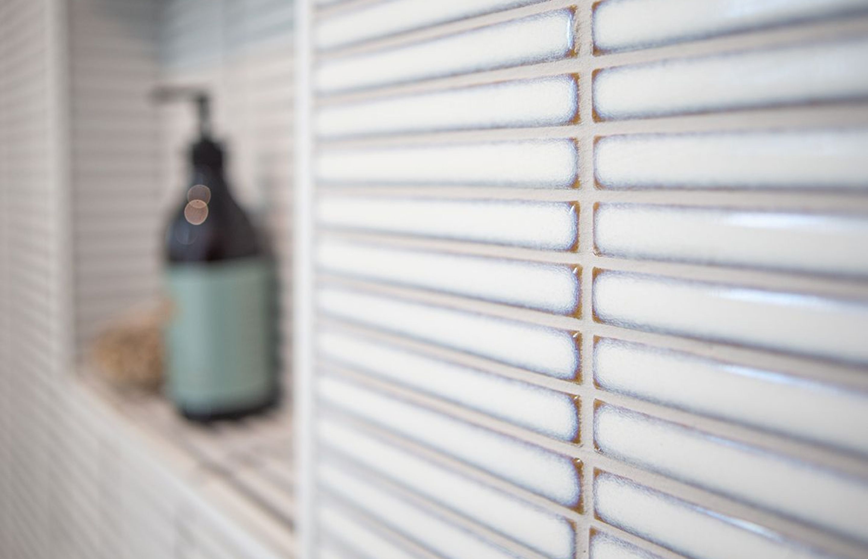 Horizontally laid finger mosaic add some colour and texture to the shower area.