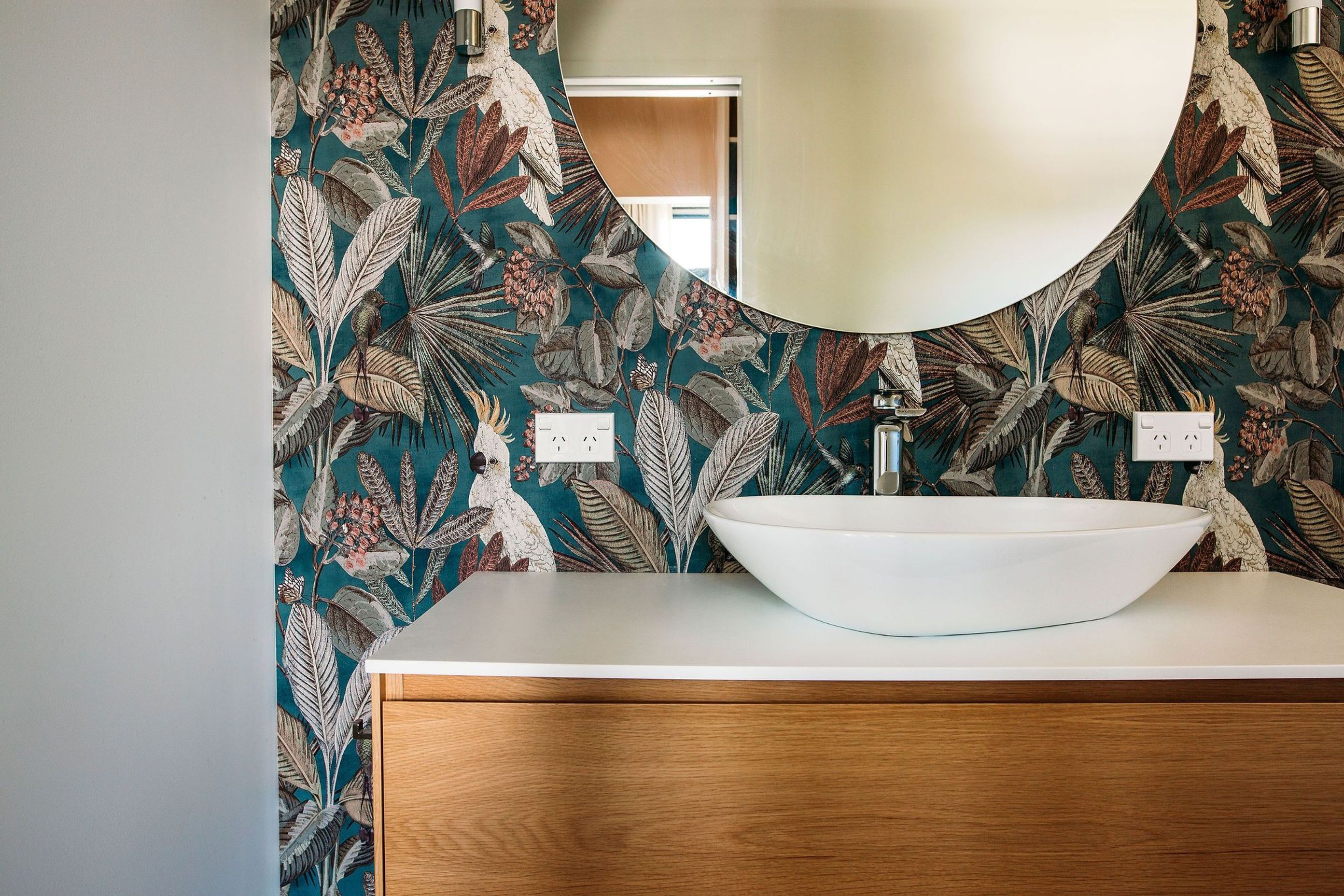 Beautiful large round mirror allows the wallpaper to shine.