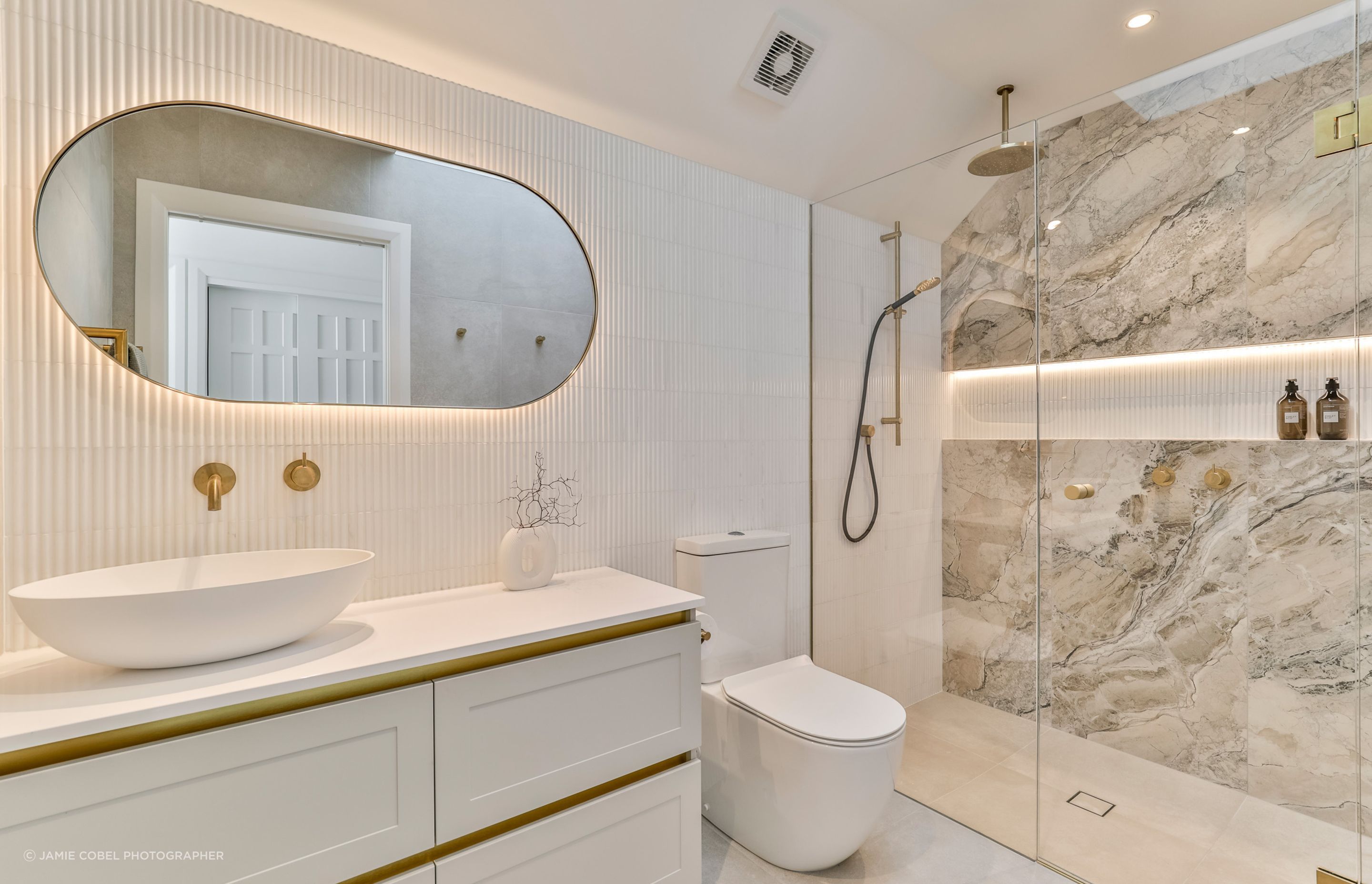 Colosseum Crystal White Mosaic with Abstract White 600x600mm on the floors and the beautiful marble-effect Charme Illusion 598x1197mm on the shower wall.