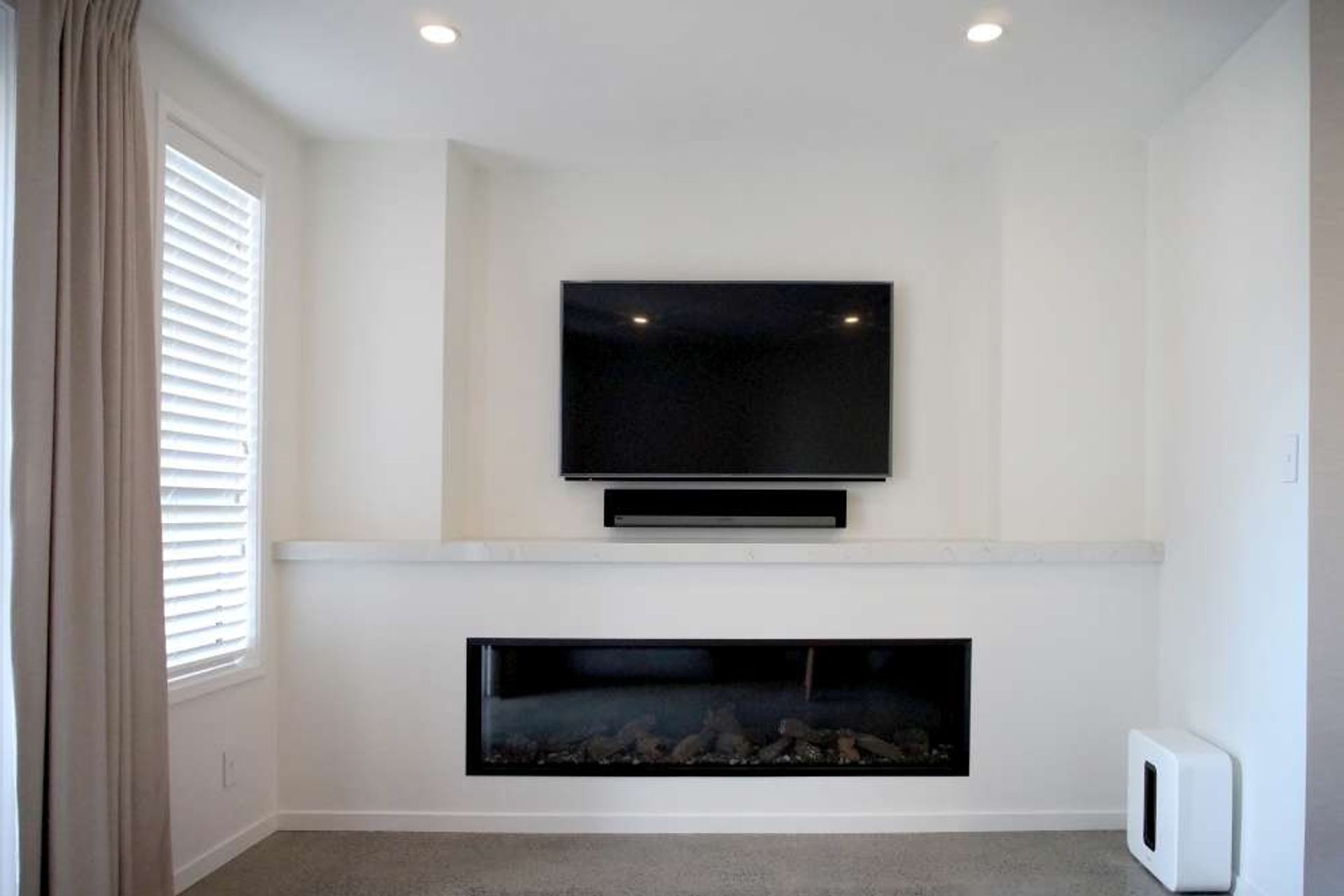 A false wall was built in front of the main wall as it was not possible to build one on the existing wall. A 30mm engineered stone (marble look) was used for the mantle of the fireplace