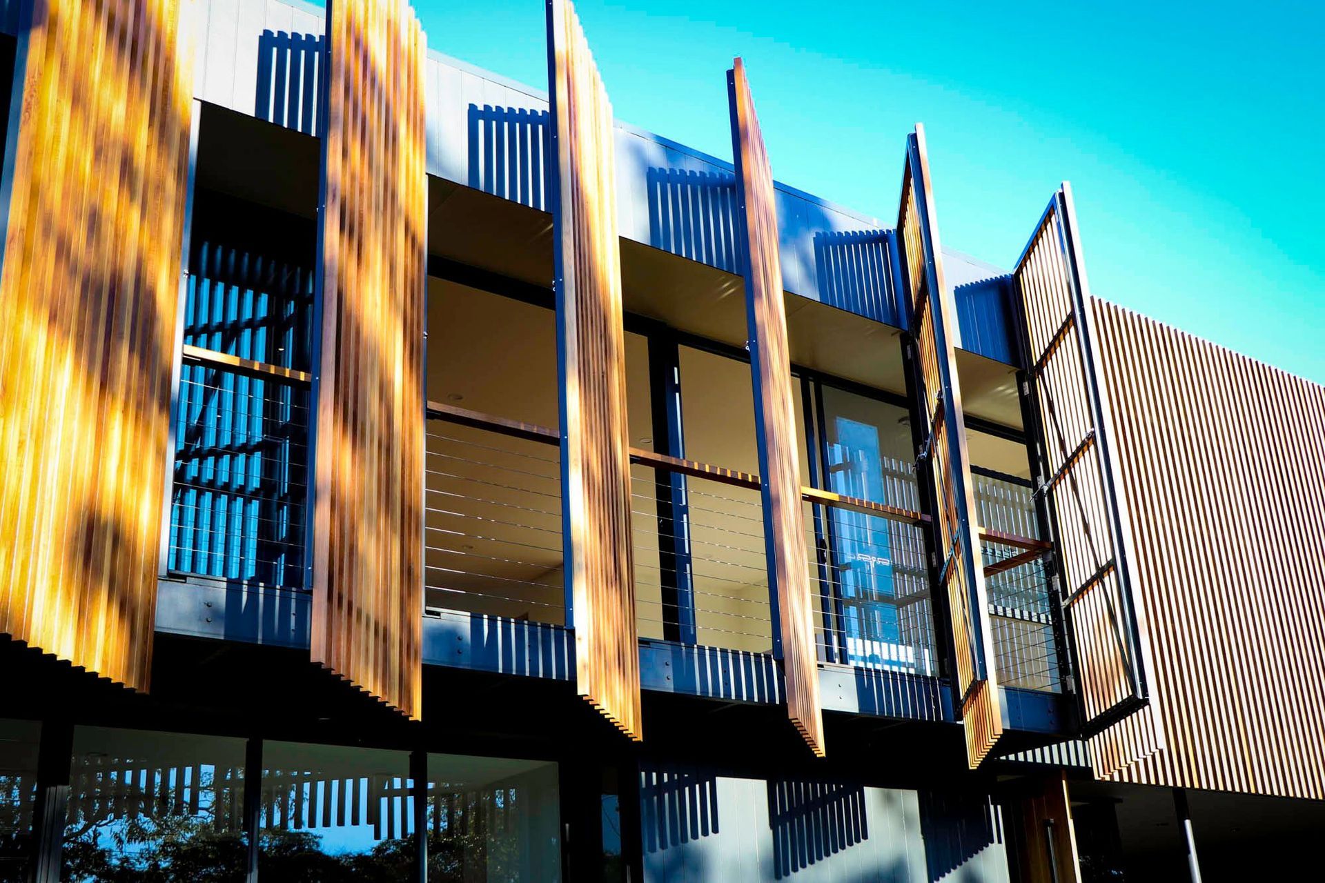Glennon Residence - Exterior. Pivoting timber screens opened along the balcony.