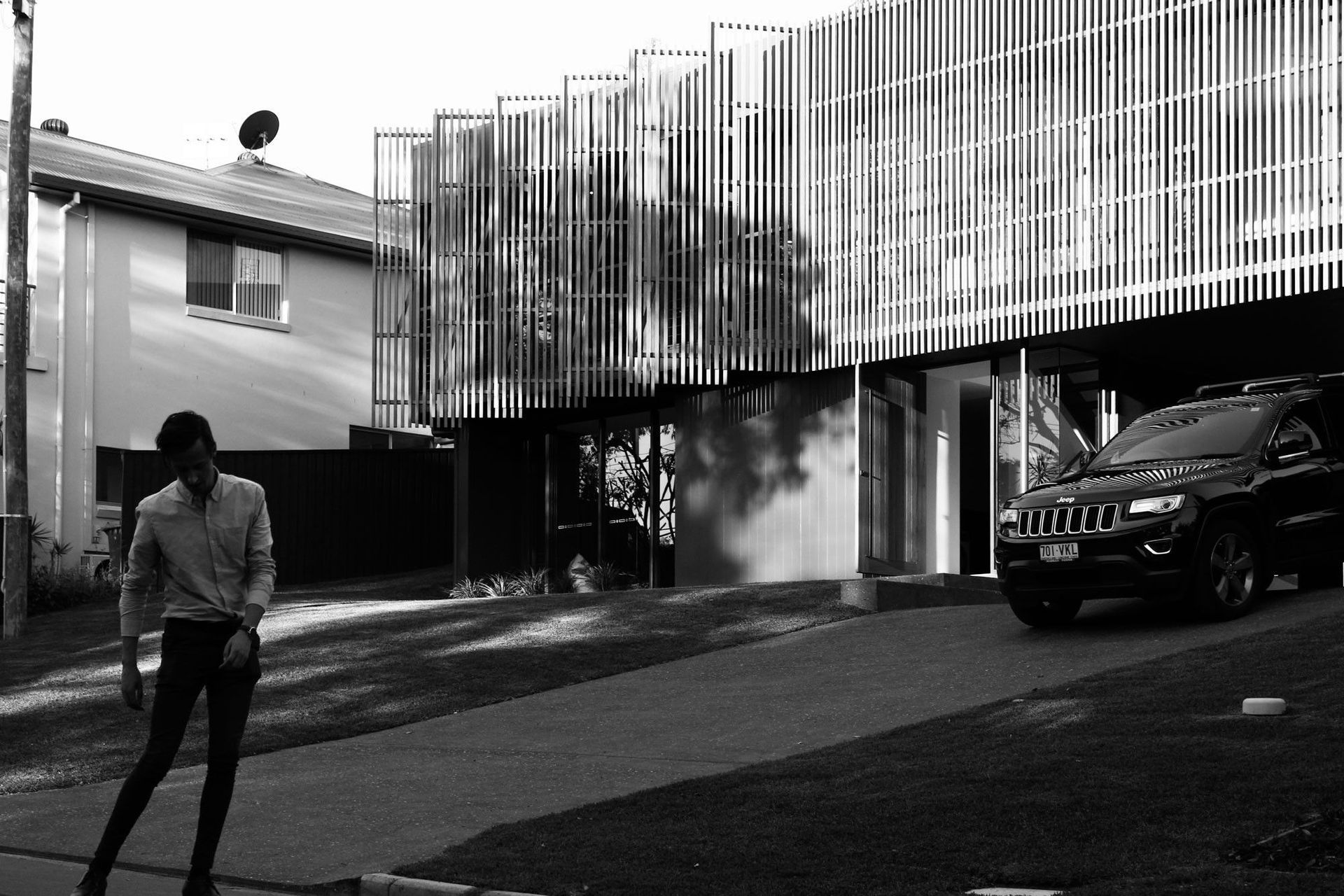 Glennon Residence - Exterior. The battened home from the street in black and white.