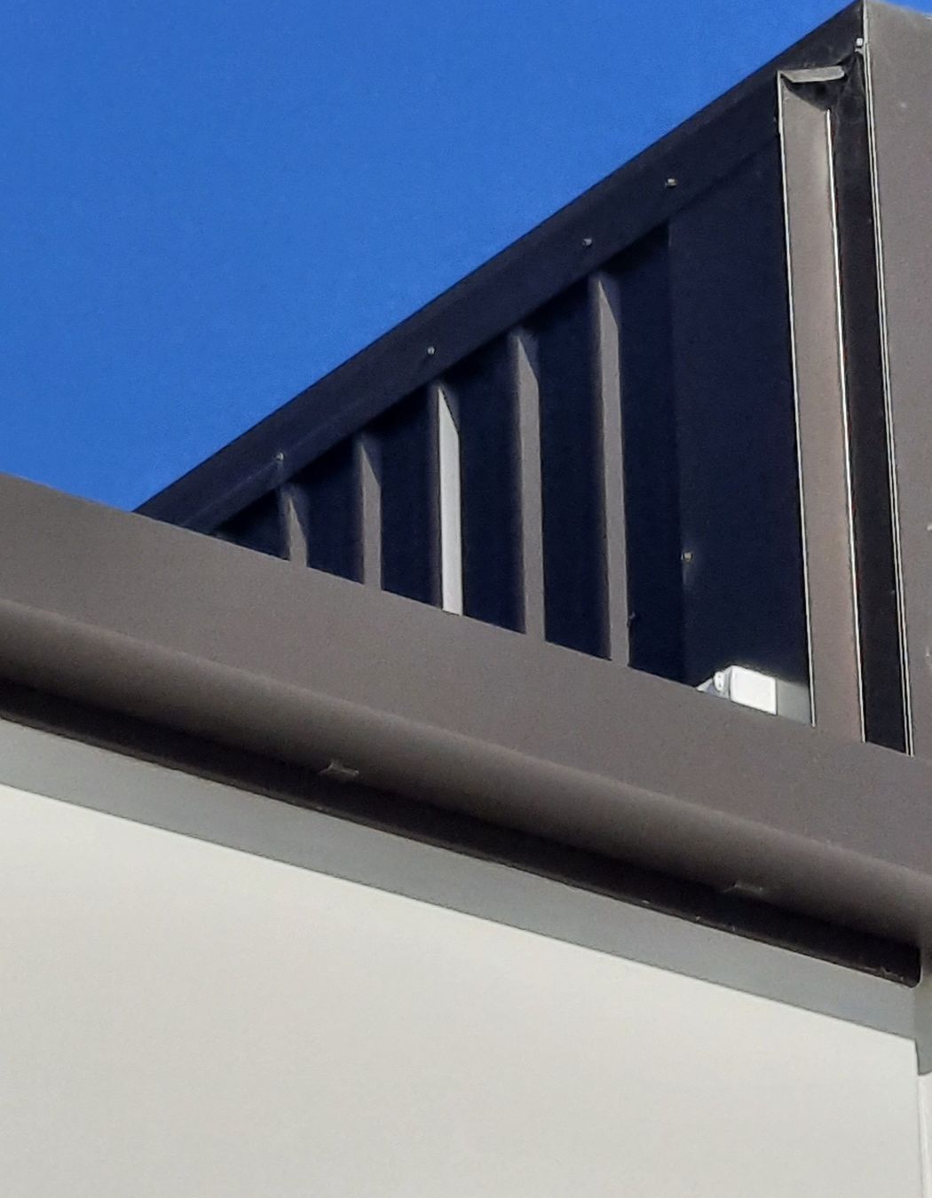 Detail of 175 Industrial Gutter “Ironsand” and vertical wall cladding to a precast concrete parapet wall