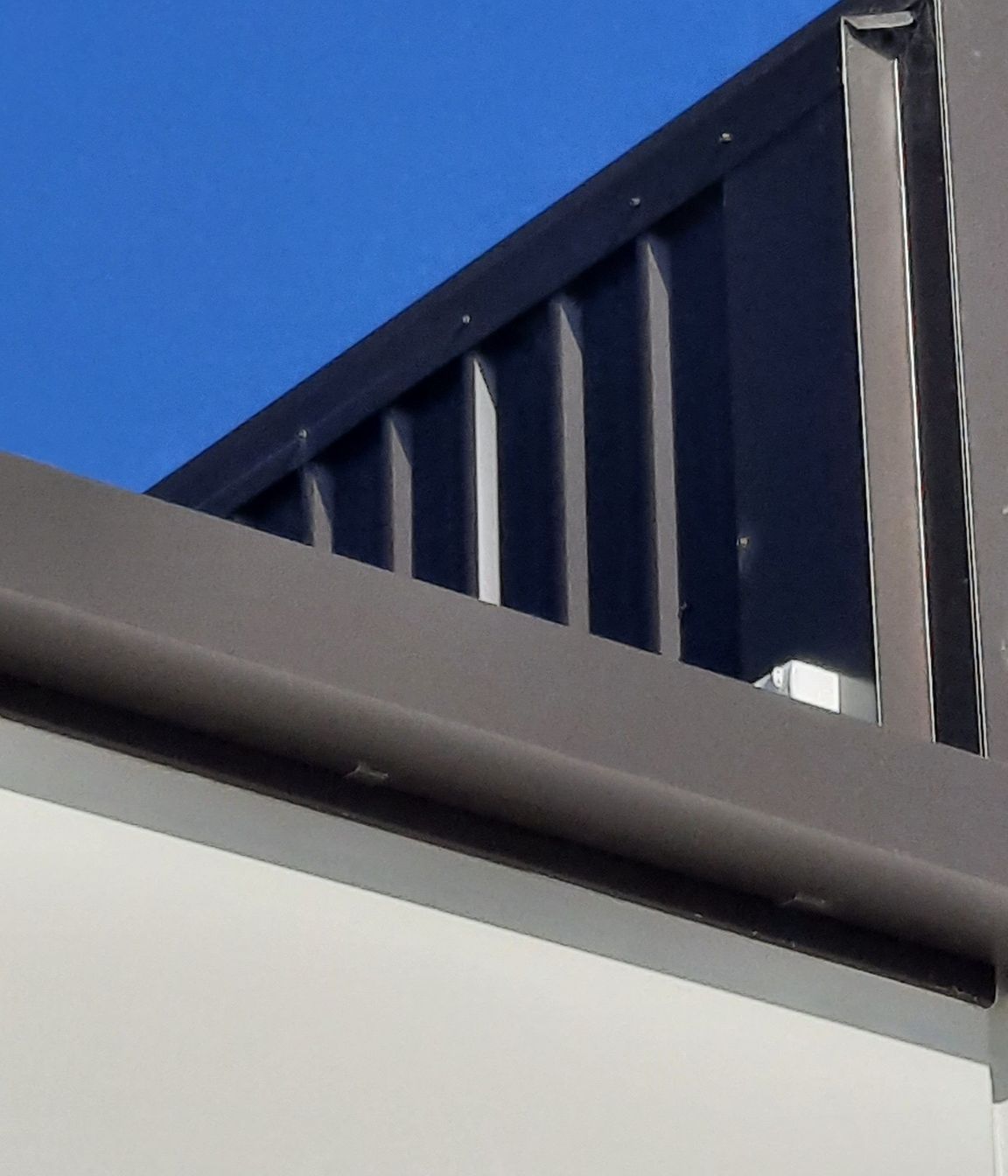 Detail of 175 Industrial Gutter “Ironsand” and vertical wall cladding to a precast concrete parapet wall