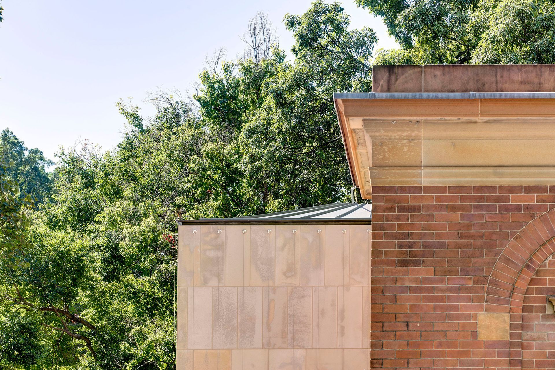 The secondary material of the existing building becomes primary in the addition.