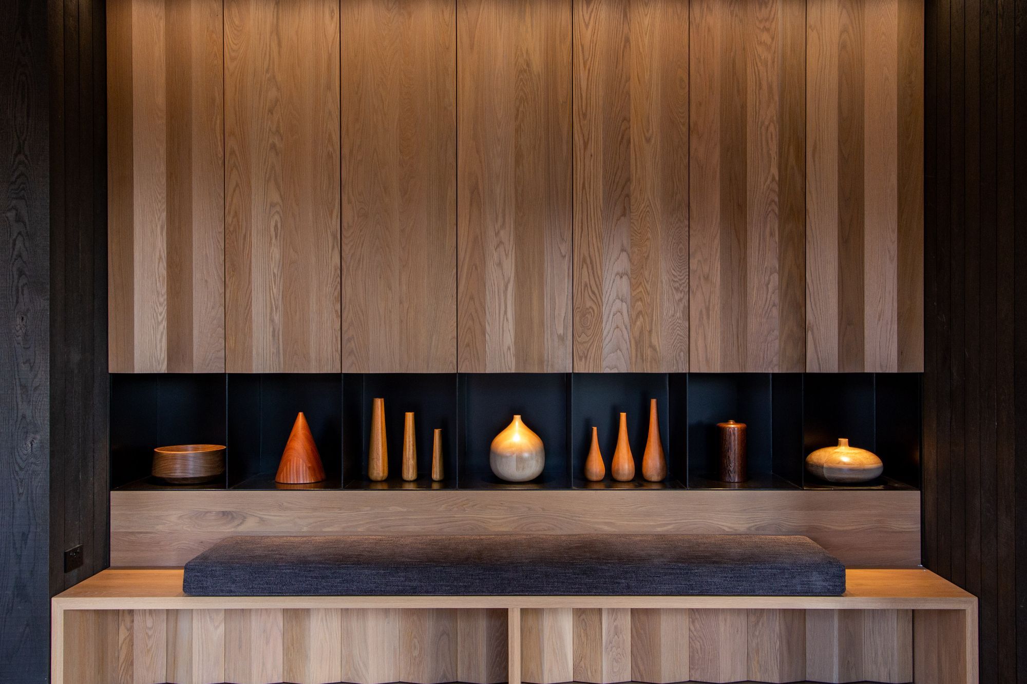 The black painted steel is designed to be recessive and let the turned wood pieces feature.