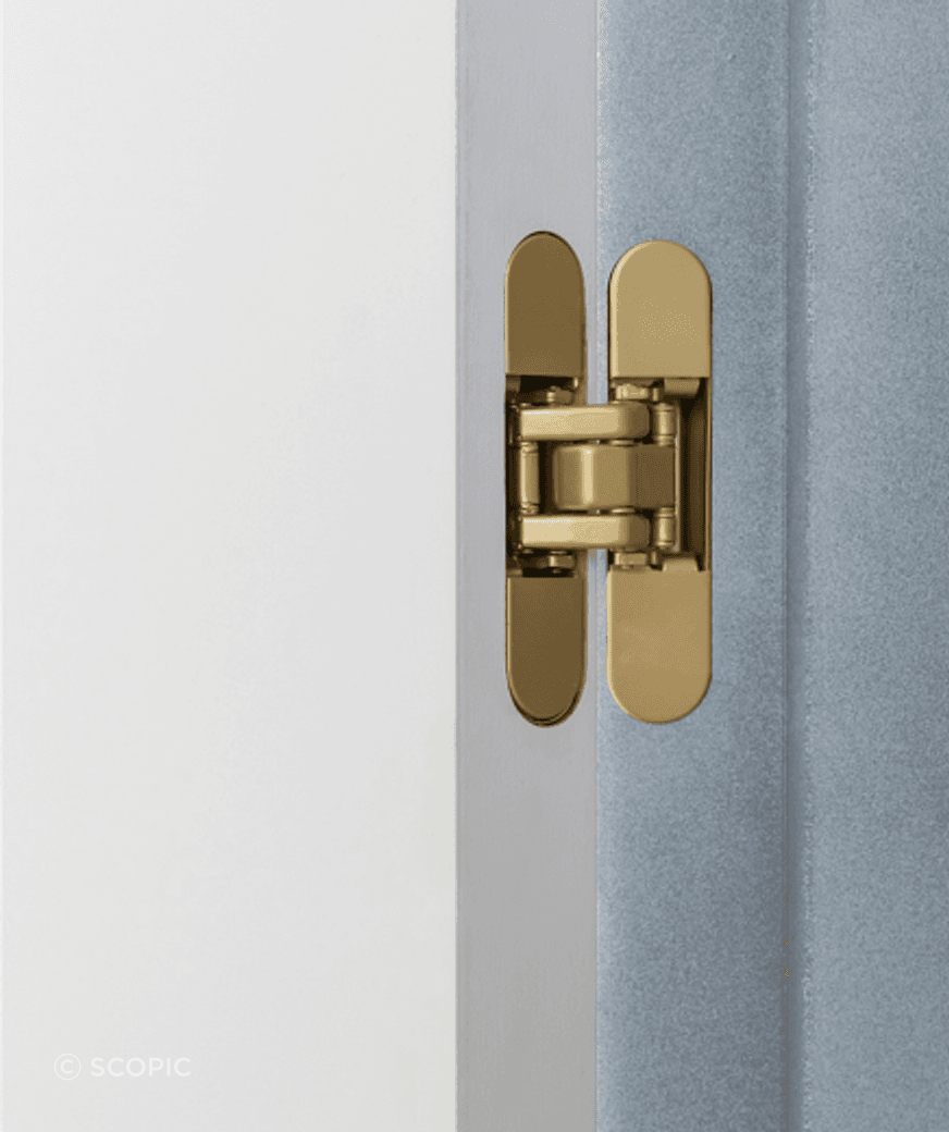 The satin brass RocYork Concealed Hinge on an open door.