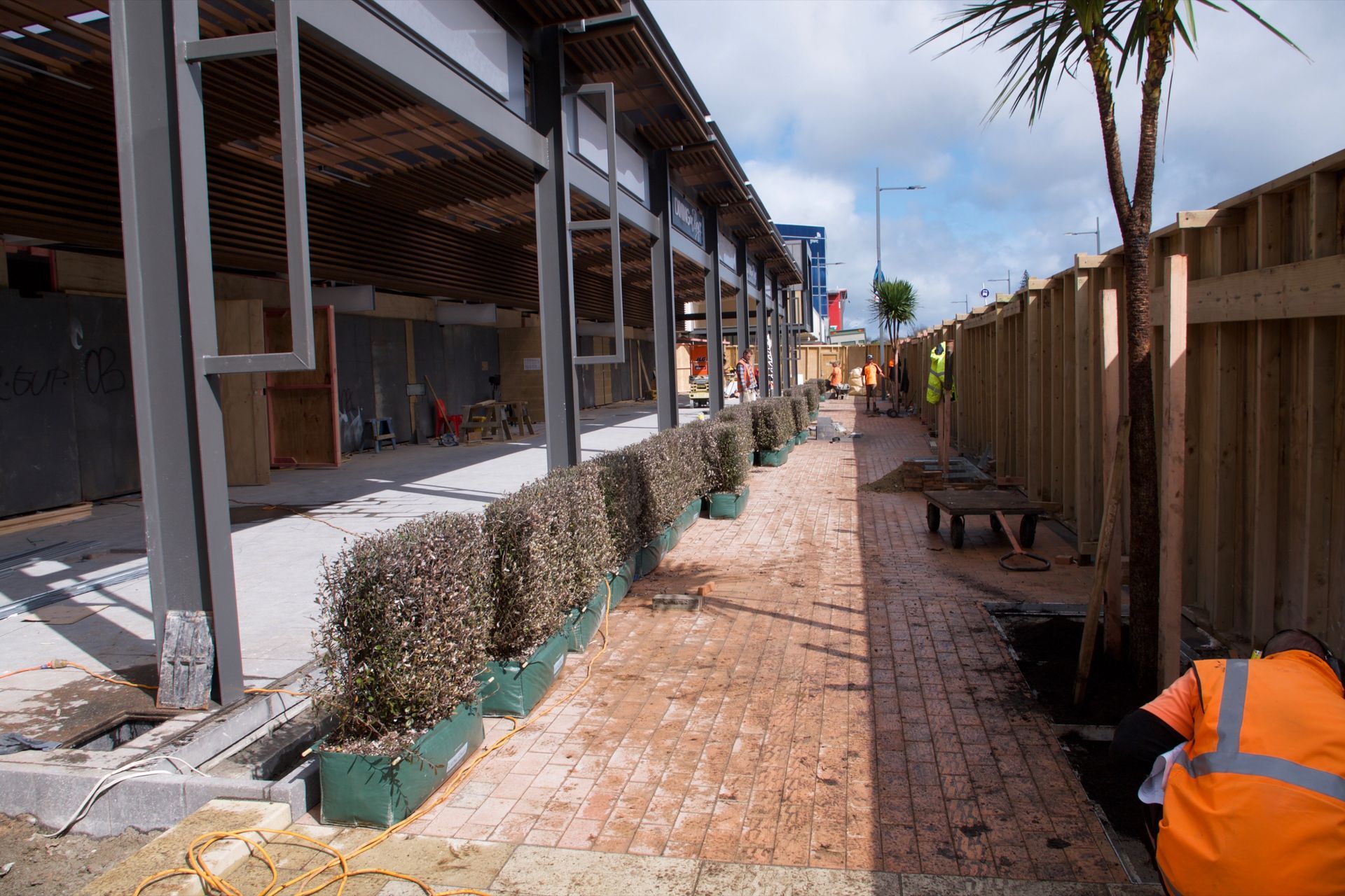 Fully formed Living Walls™ hedge lengths positioned next to planter boxes before installation.