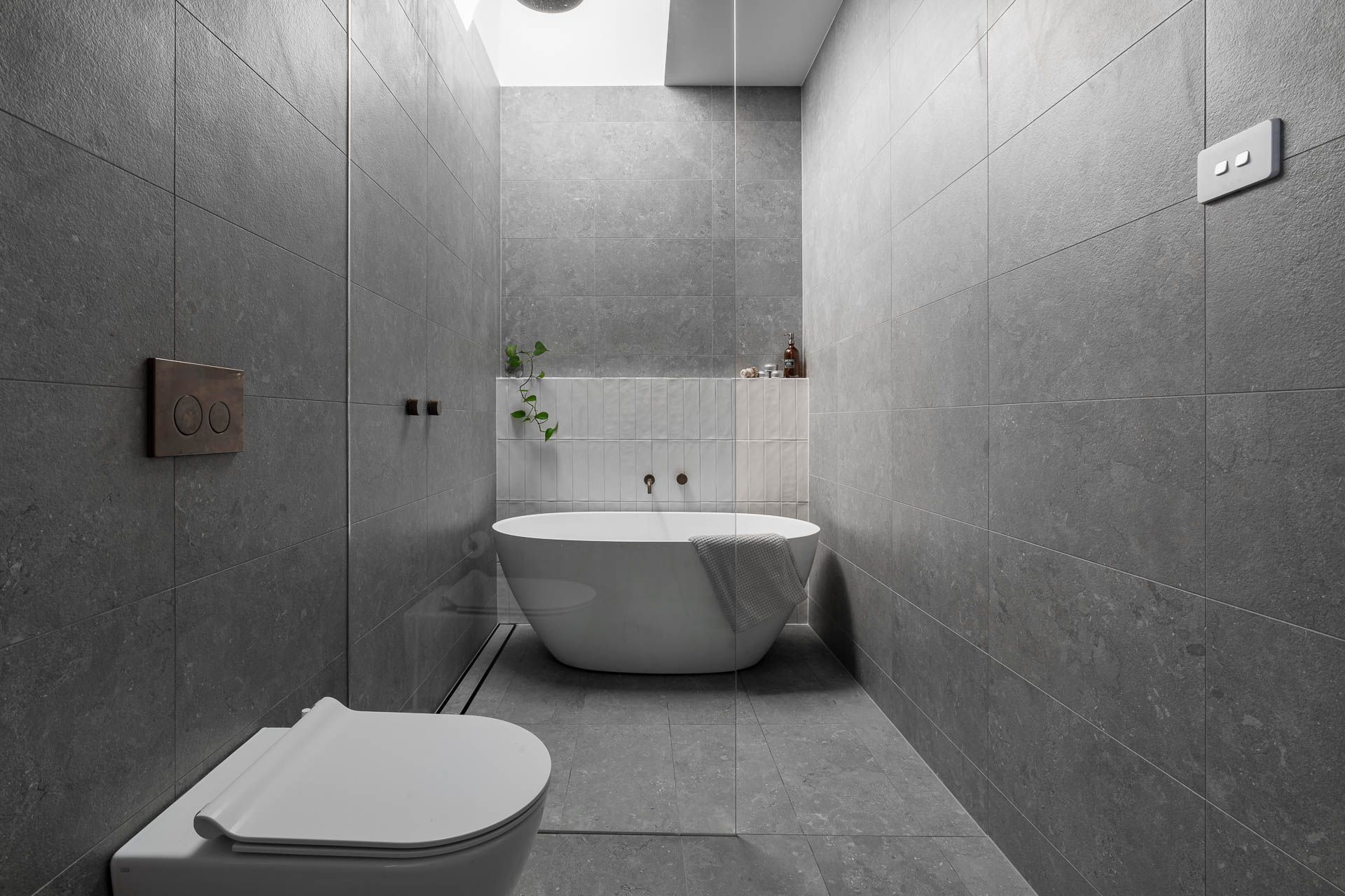 Freestanding bathtub and large overhead skylights, creating an airy and serene atmosphere