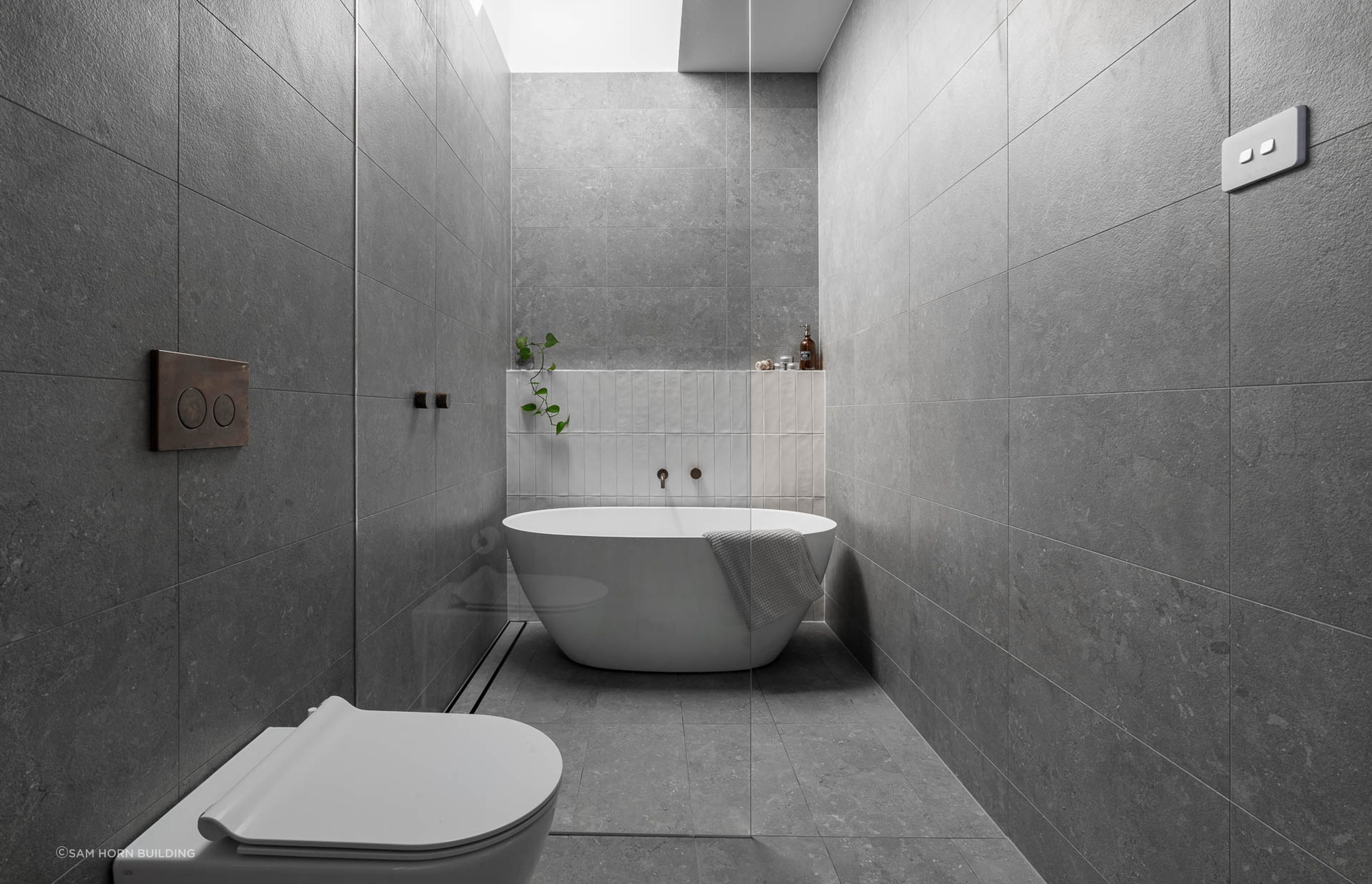 Freestanding bathtub and large overhead skylights, creating an airy and serene atmosphere