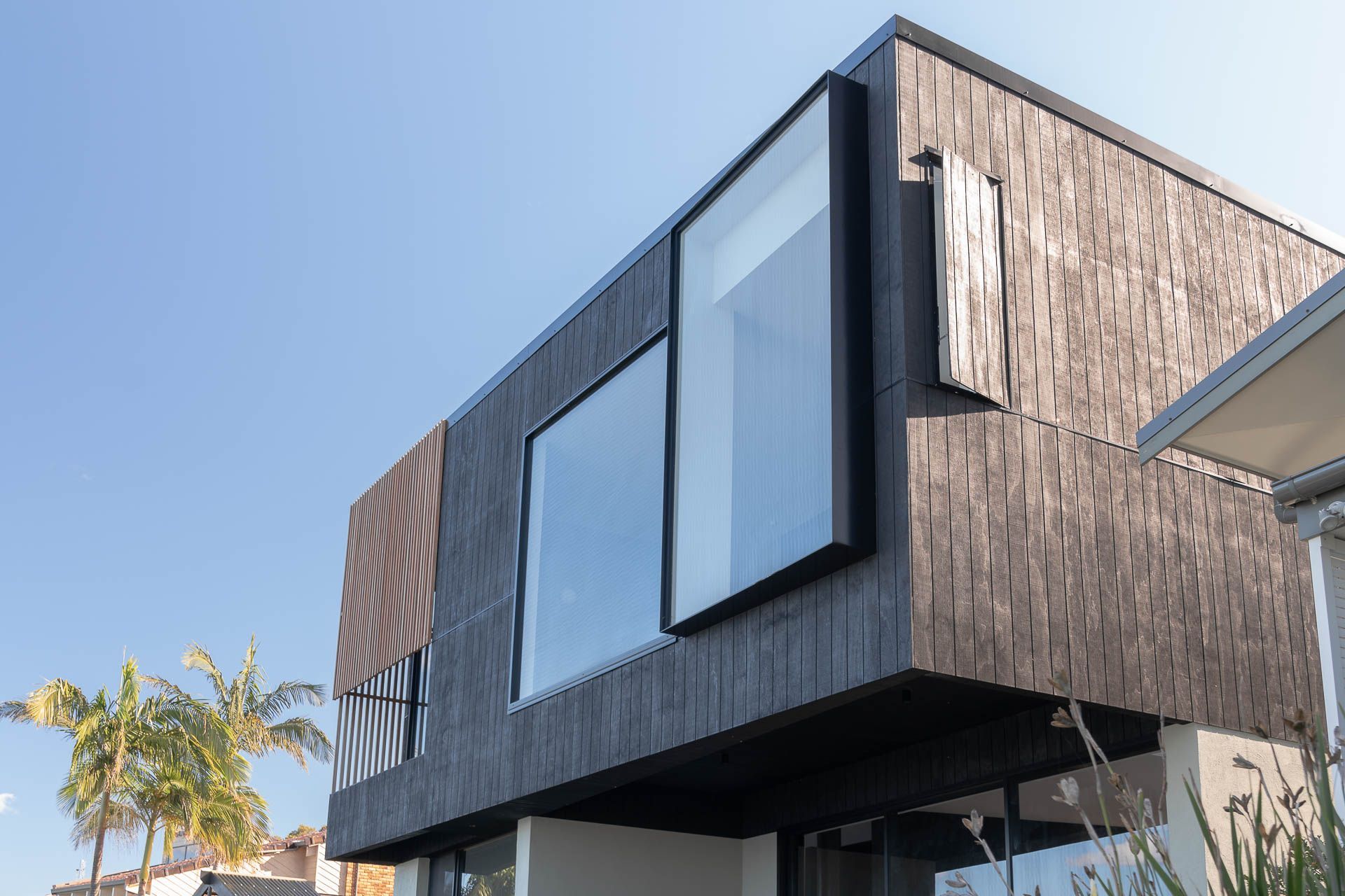 External facade is a captivating combination of charring effect texture paint and blackbutt timber battens