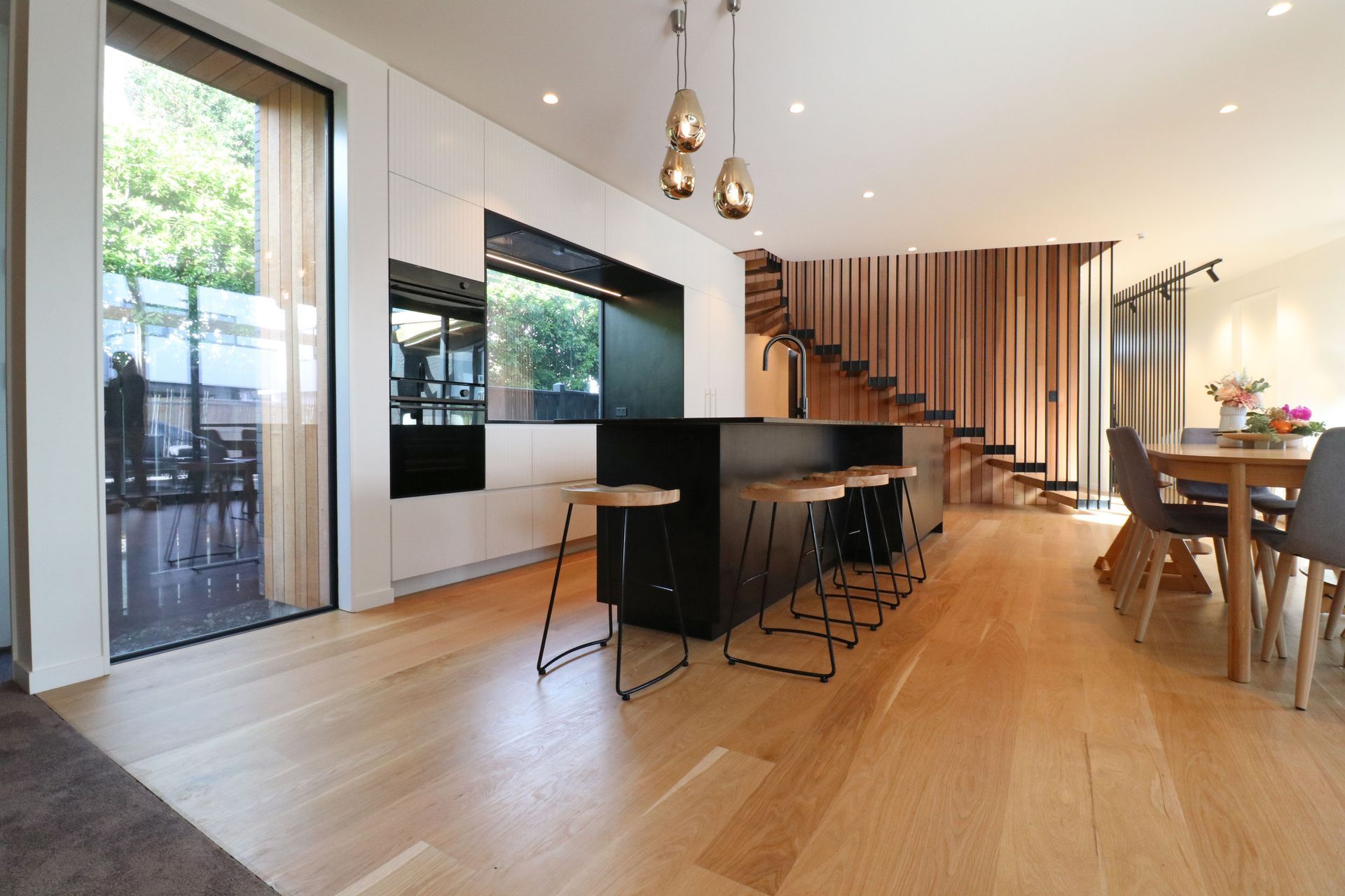 White V groove, black island and a scullery with a touch of pink