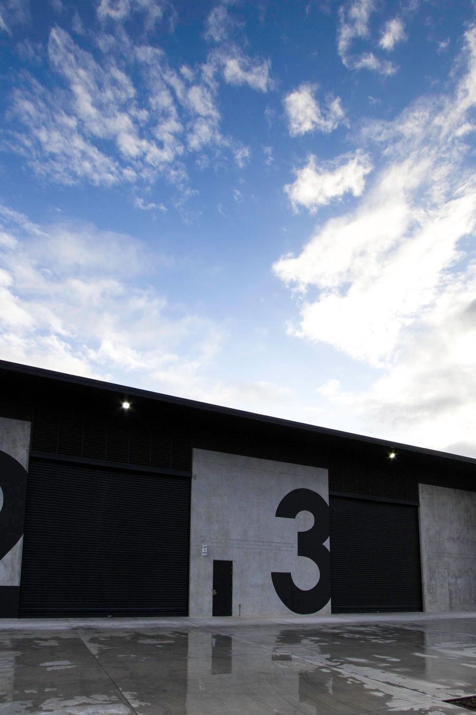 Eniquest Warehouse - Exterior. Dark roof edge against the clouds.