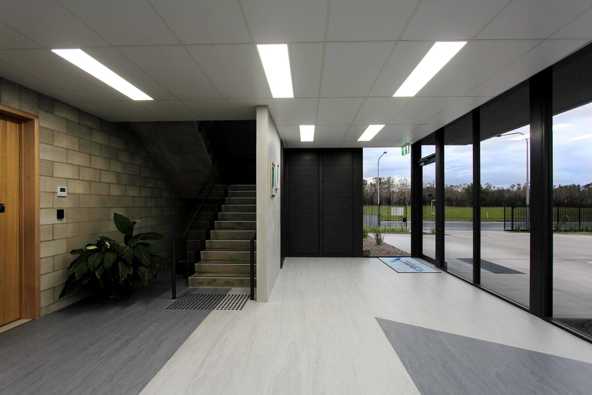 Eniquest Warehouse - Office. Office entry with a concrete stair and glazed frontage.