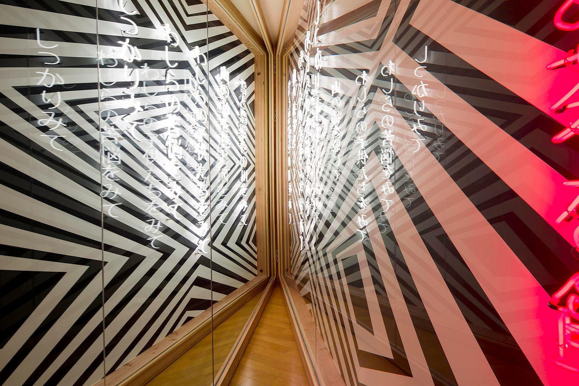 Brook Andrew's artwork 'Mountain Home - dhirrayn ngurang'. The artist created a poem with the local community. The neon kanji characters are backwards, and therefore can only be ready in the mirror. When viewing the mirror, the viewer sees the landscape and reads themselves into the place and the landscape.