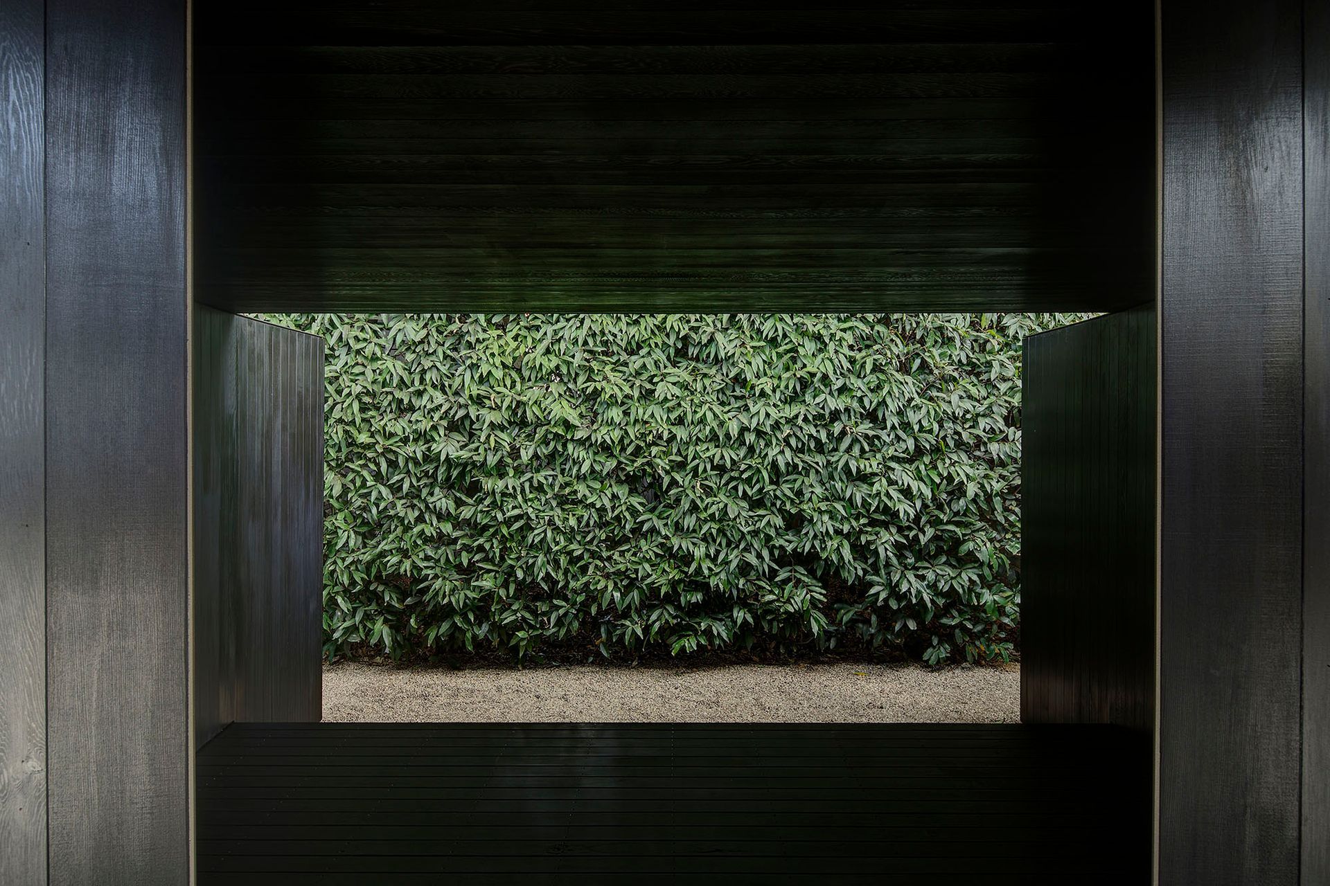 The pavilion frames a Rose Apple hedge.