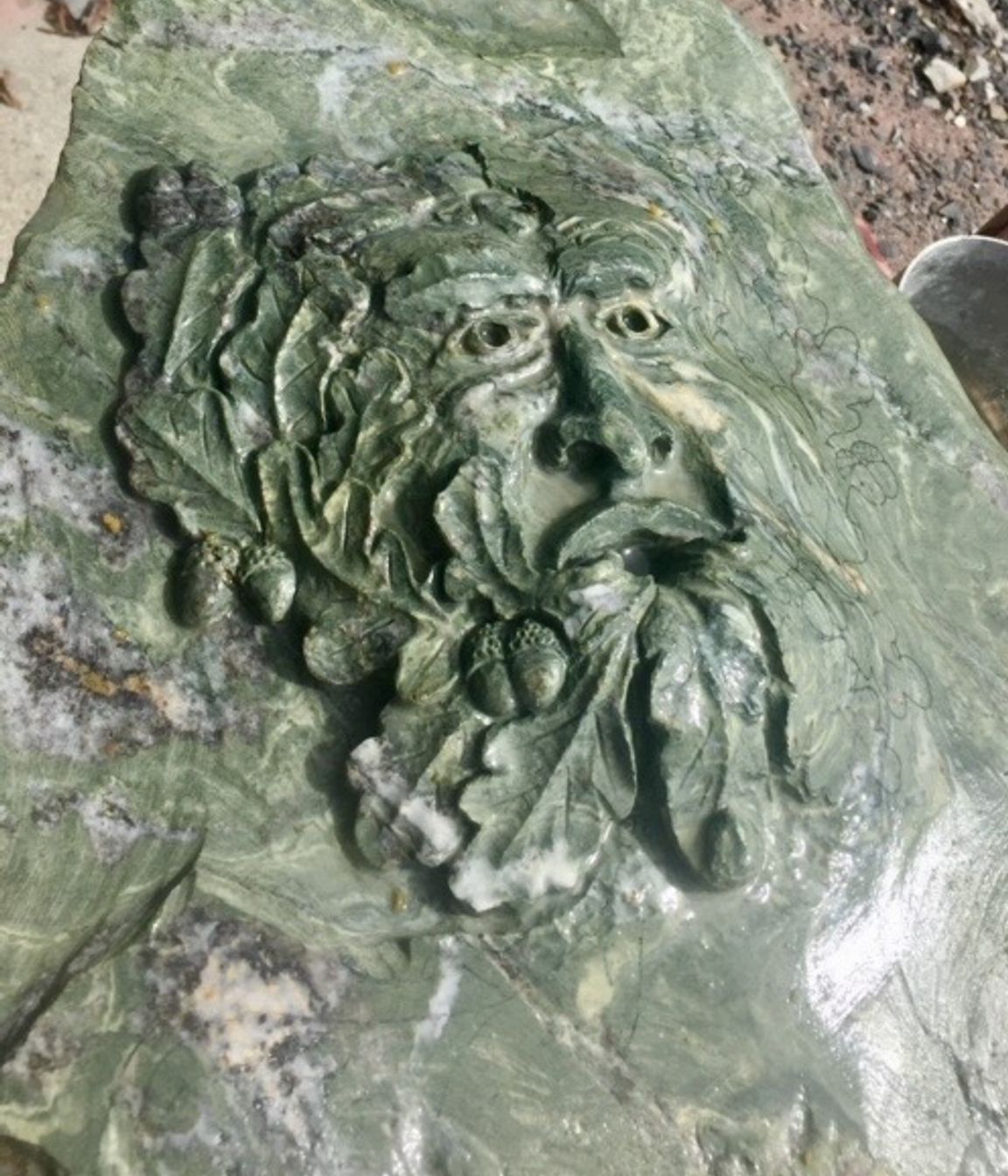 Carved Green man in green schist by Paul Gautron