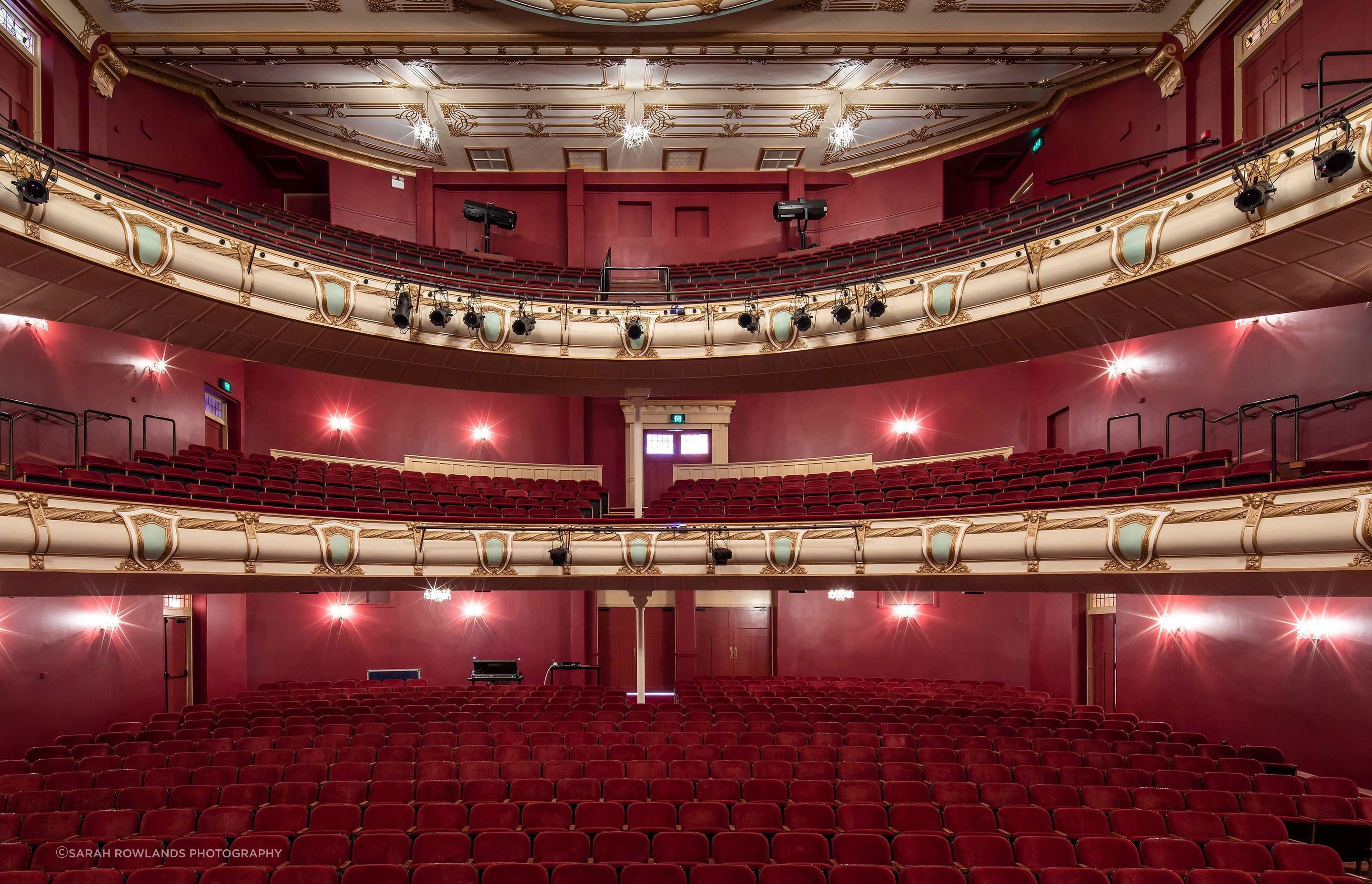 Within the auditorium, the goal was to create a rich interior to create a sense of occasion befitting the building’s use as an opera house while still tying in with the existing mural on the ceiling.