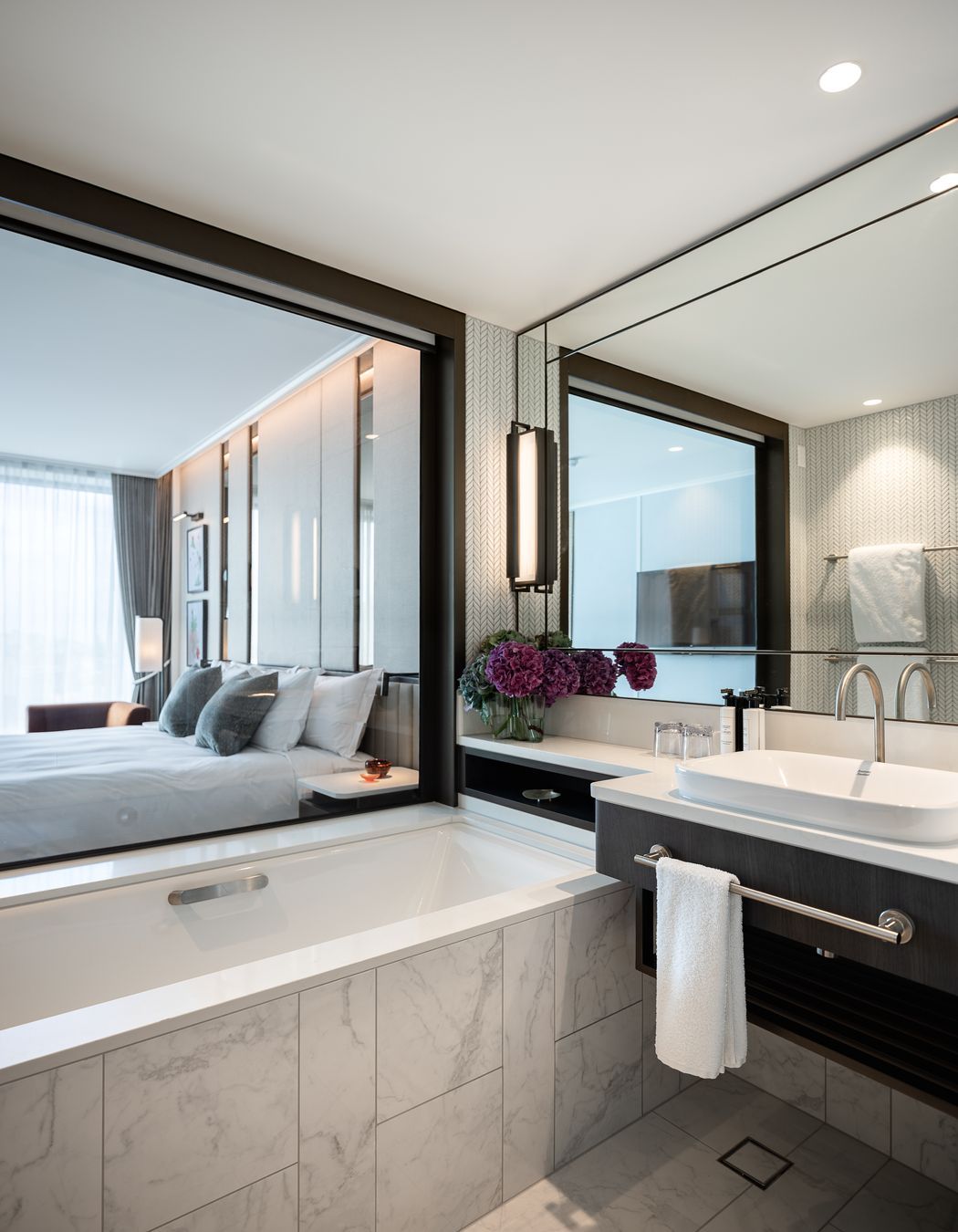A hotel room en suite reflects the light through expansive mirrors.
