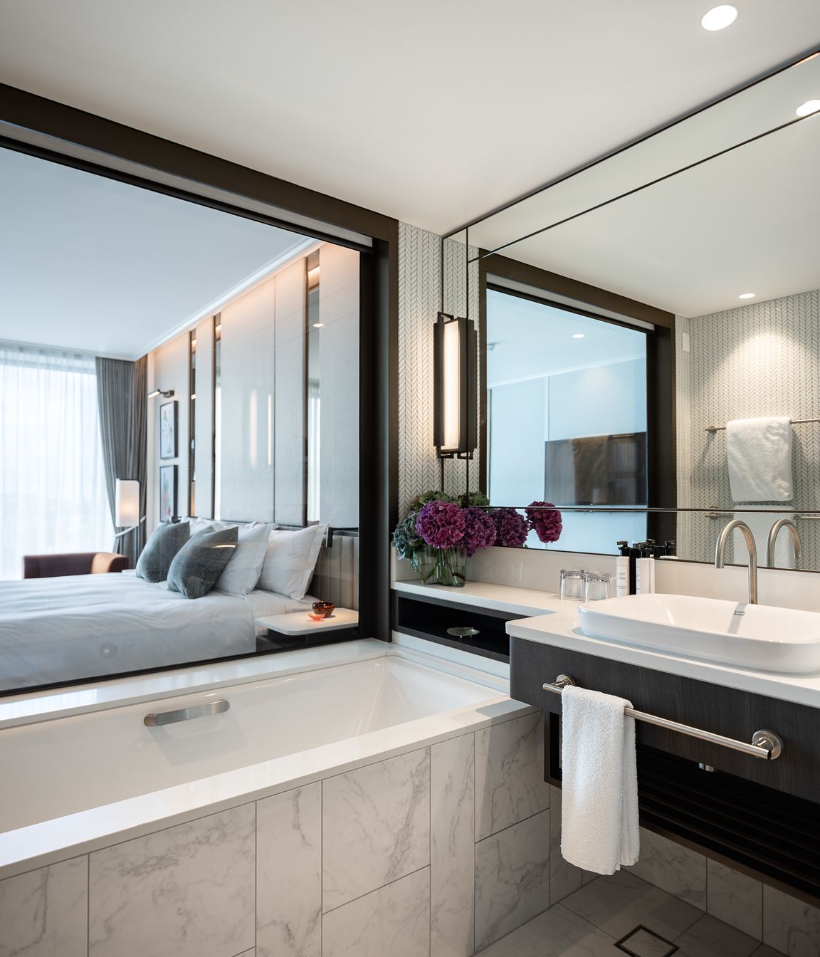 A hotel room en suite reflects the light through expansive mirrors.