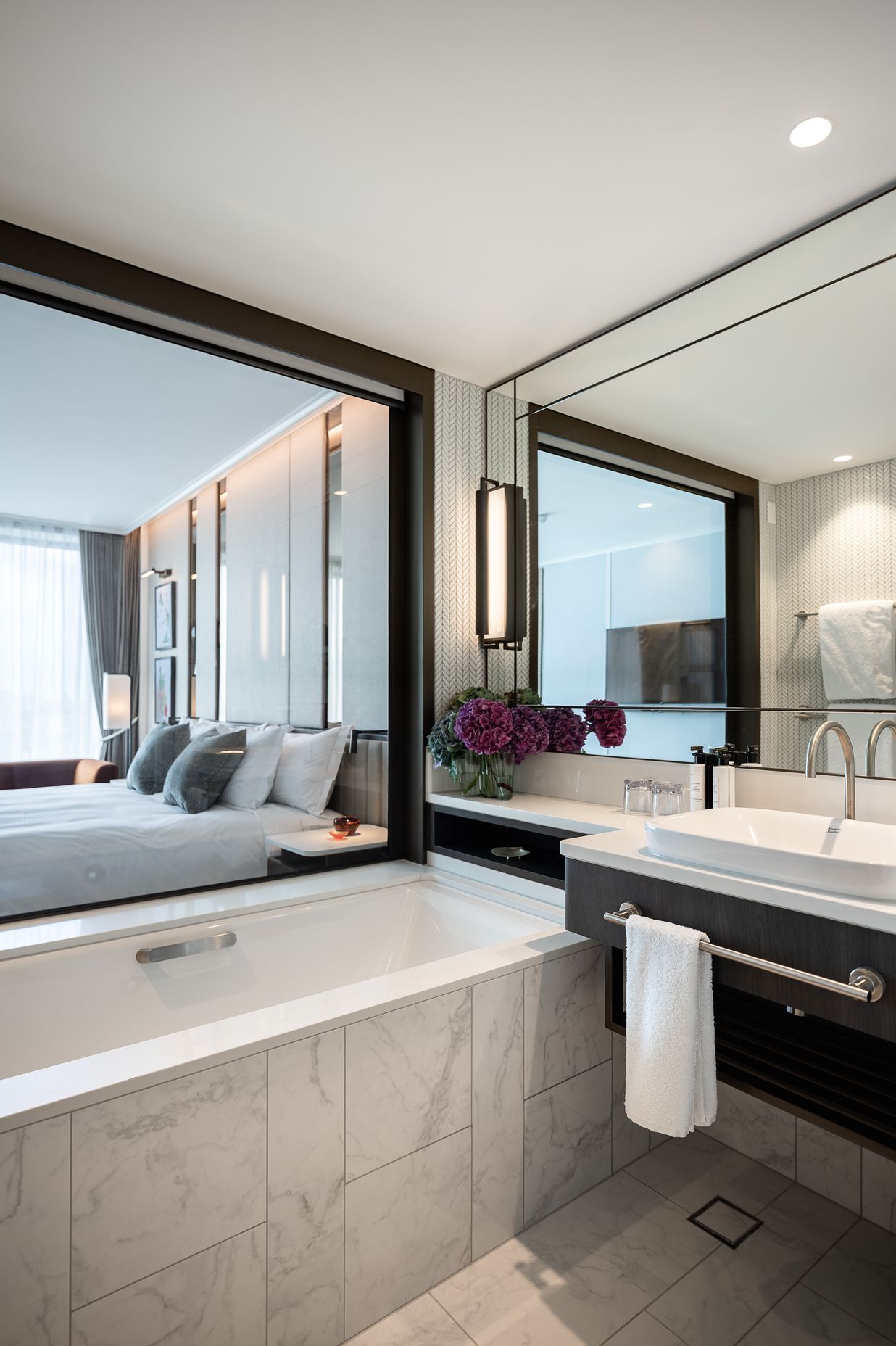 A hotel room en suite reflects the light through expansive mirrors.