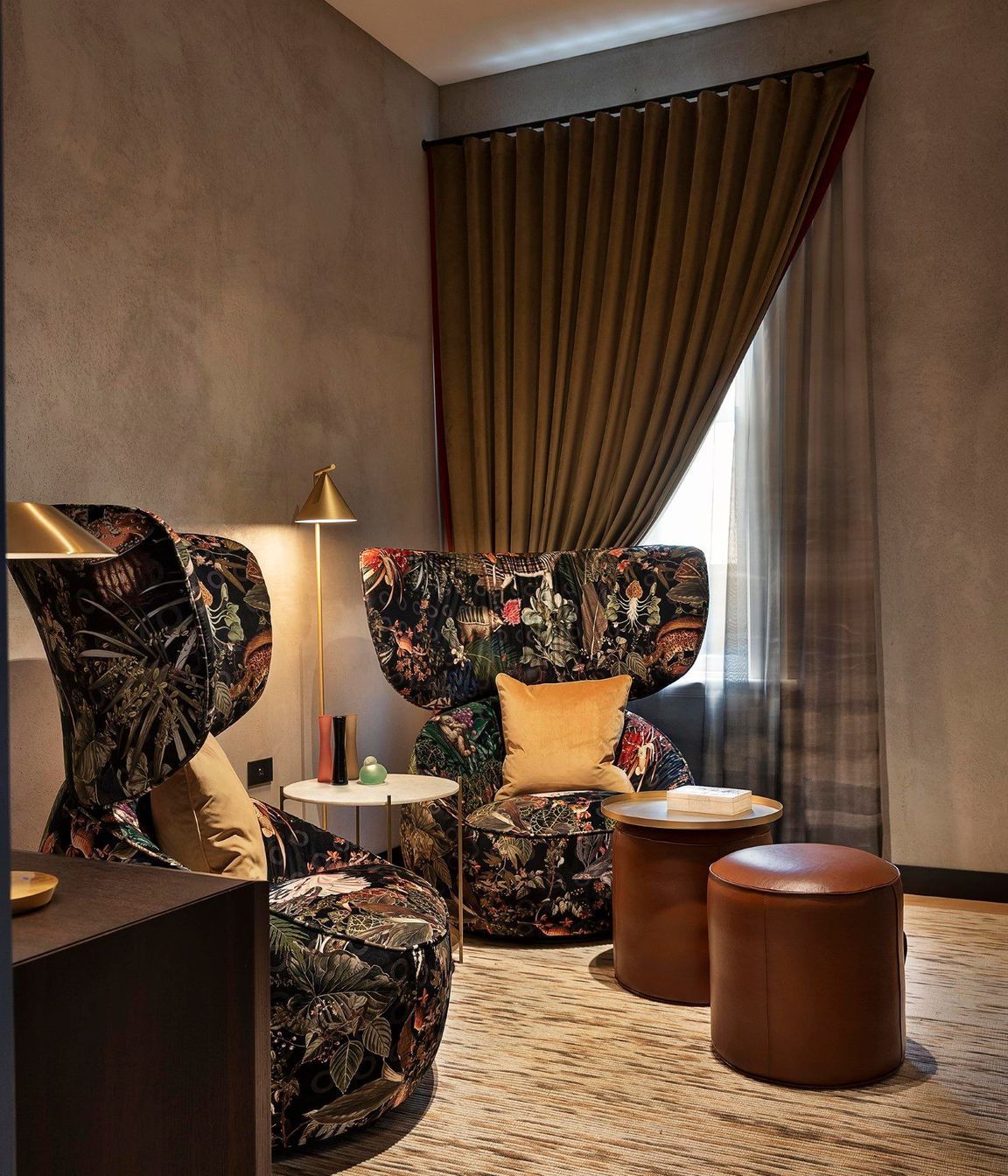 The waiting room features oversized Moooi chairs and leather ottomans for a relaxed and warm reception.