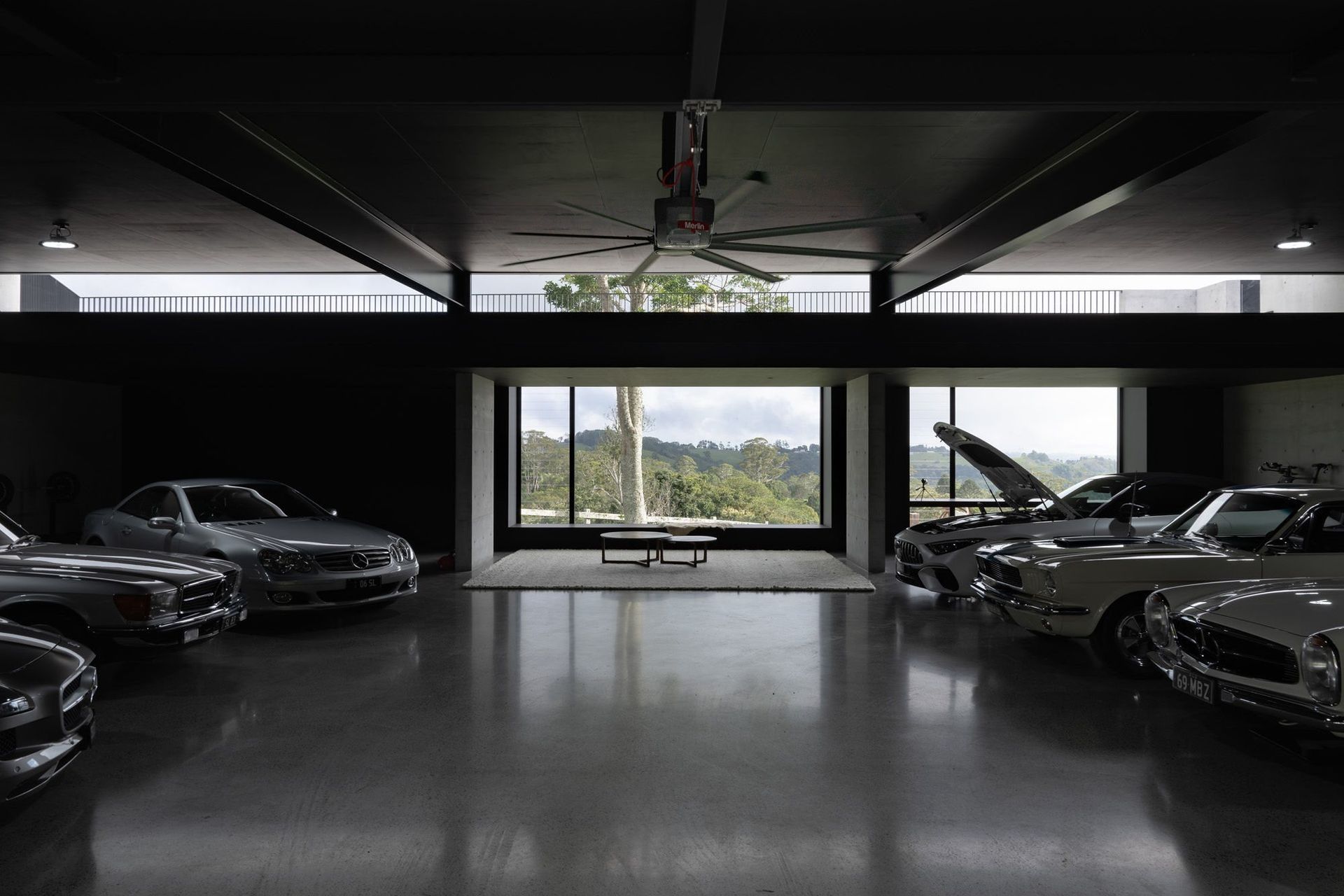 The Farm - Garage. Classic cars lined up beneath a dark ceiling and picture window.