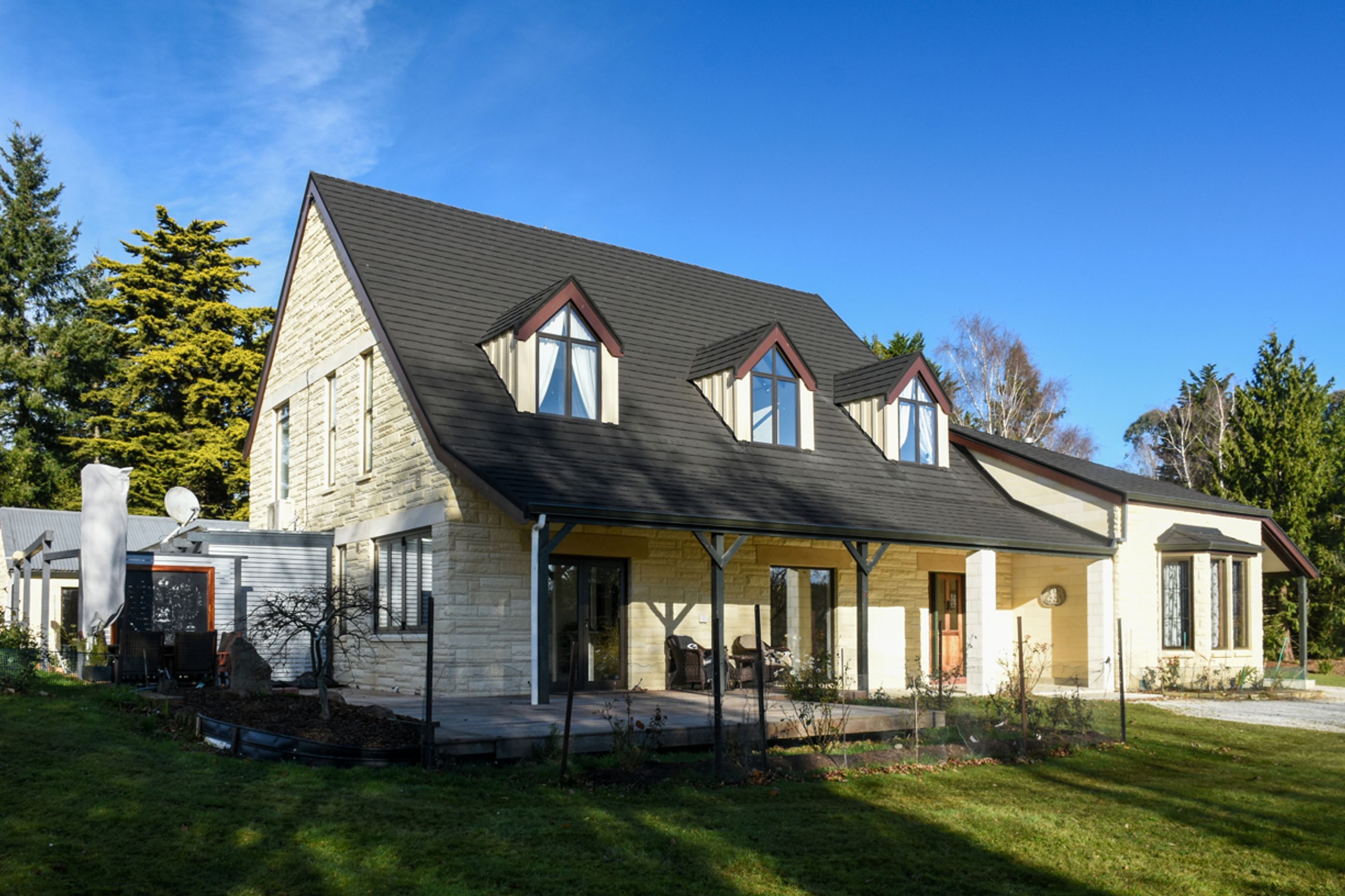 Front three quarter view - new roofing with slate alternative, double-glazed windows, bargeboards over dormer windows, restoration/cleaning of Oamaru stone