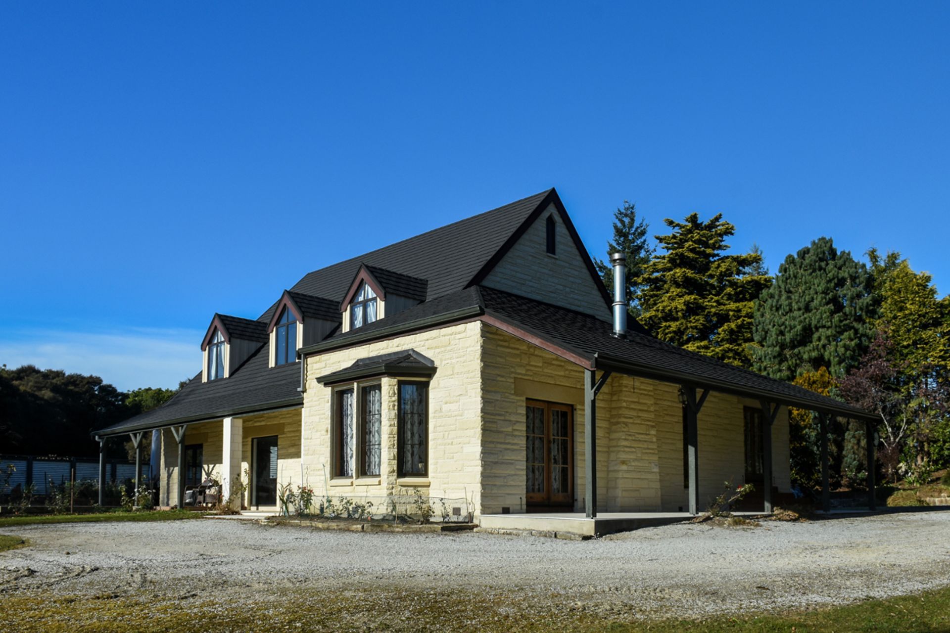 Three quarter view - new roofing with slate alternative, double-glazed windows, bargeboards, restoration/cleaning of Oamaru stone and porcelain tiling along the side.
