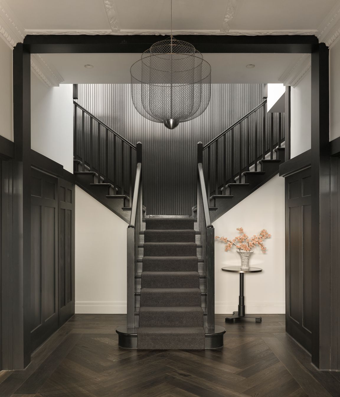 A grand entry stair crowned by a dramatic chandelier sets the tone on arrival, refined and bold.