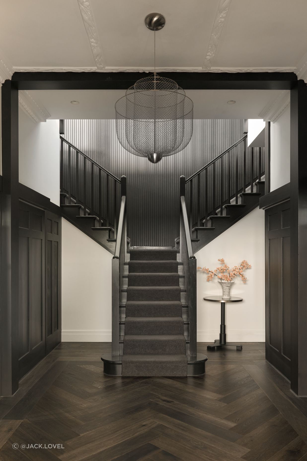A grand entry stair crowned by a dramatic chandelier sets the tone on arrival, refined and bold.