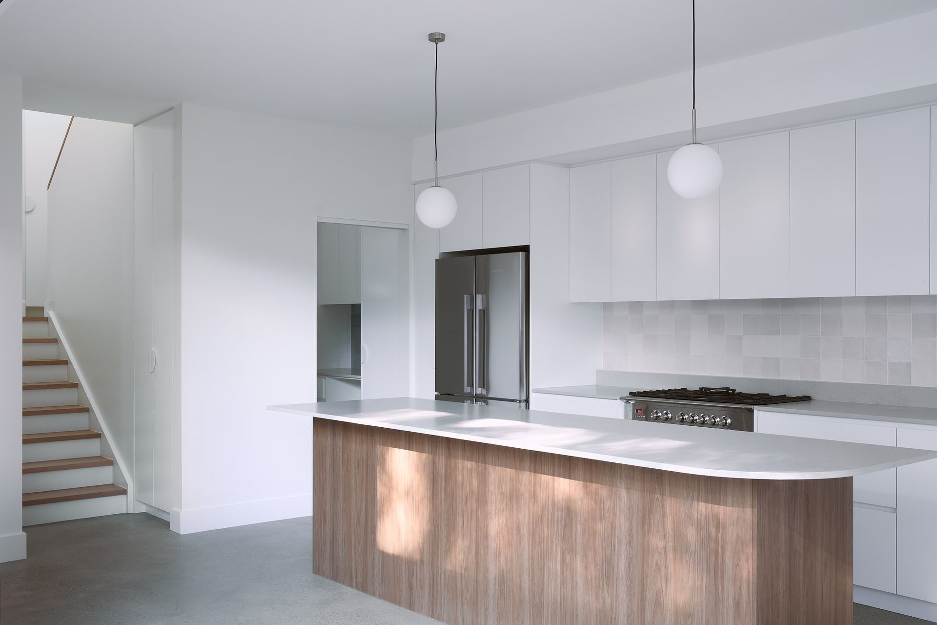 Following the contour of the site, the kitchen, living and other wet areas sits below street level, accessed through a transitional space where the original dwelling terminated.