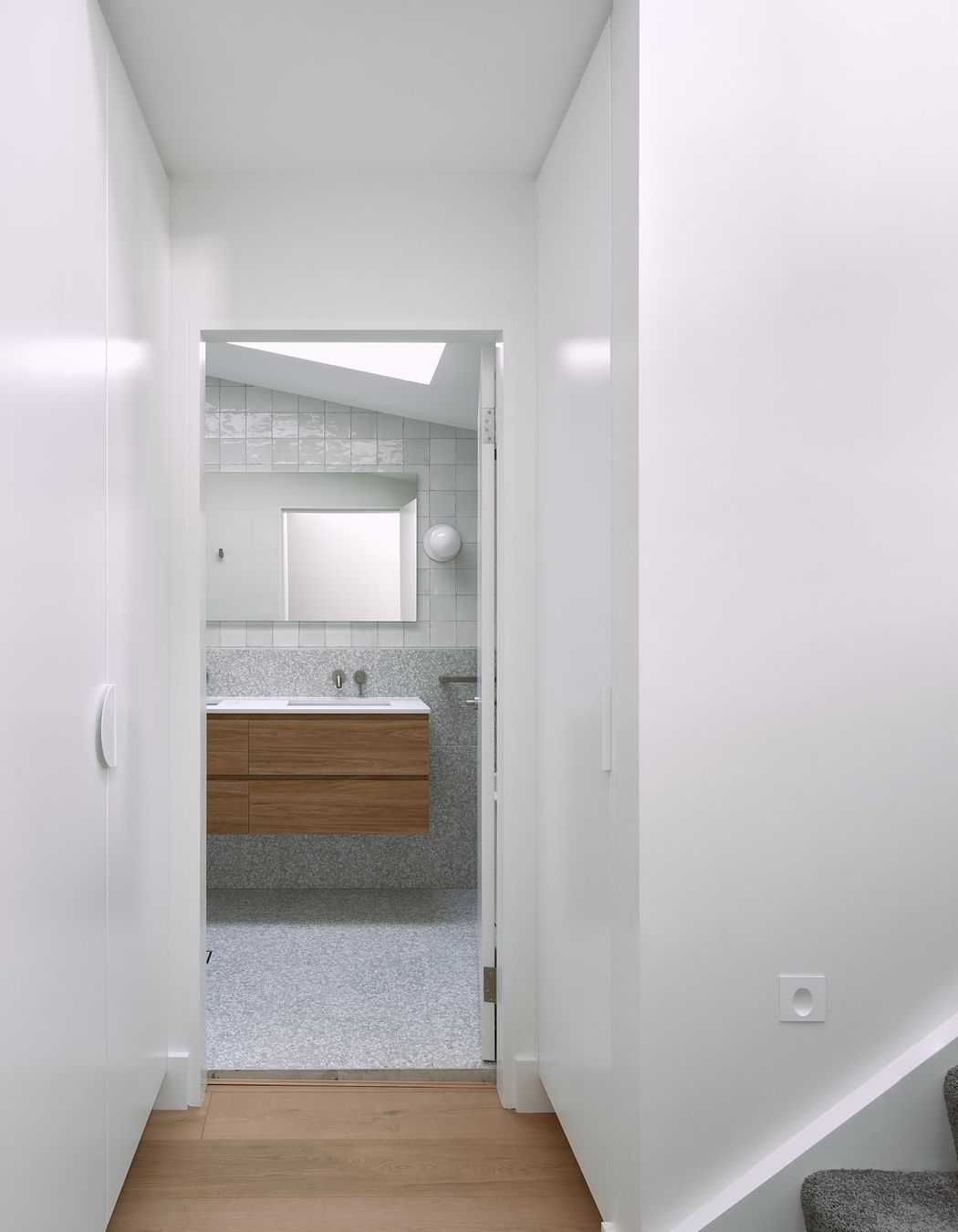 The entry to the shared bathroom, located in the transitional zone of the home, is graced with custom joinery, maximising the space available.