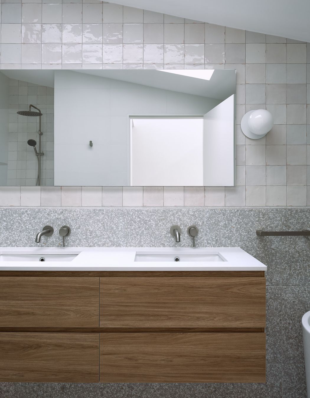 Materials with neutral tones are contrasted with darker pallet natural materials. Maximising texture allows a gradient of tones on light colour materials caused by the overhead skylight.