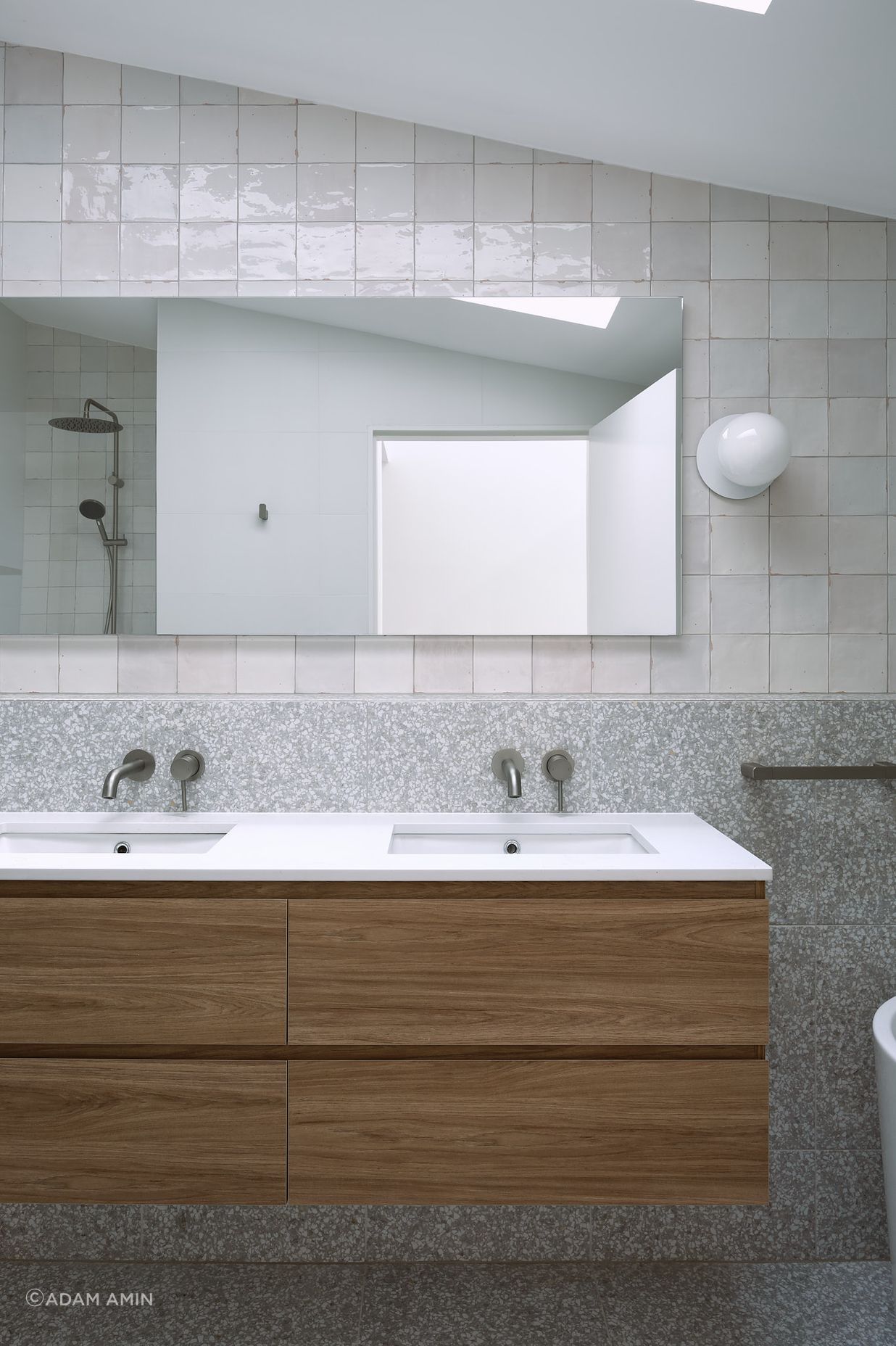 Materials with neutral tones are contrasted with darker pallet natural materials. Maximising texture allows a gradient of tones on light colour materials caused by the overhead skylight.