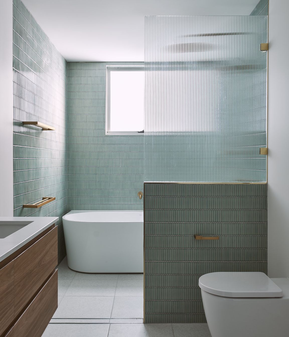 Green finger tiles and fluted glass cut the ensuite to a different class. Brass fixtures and ornate lights embellish the private bathroom.