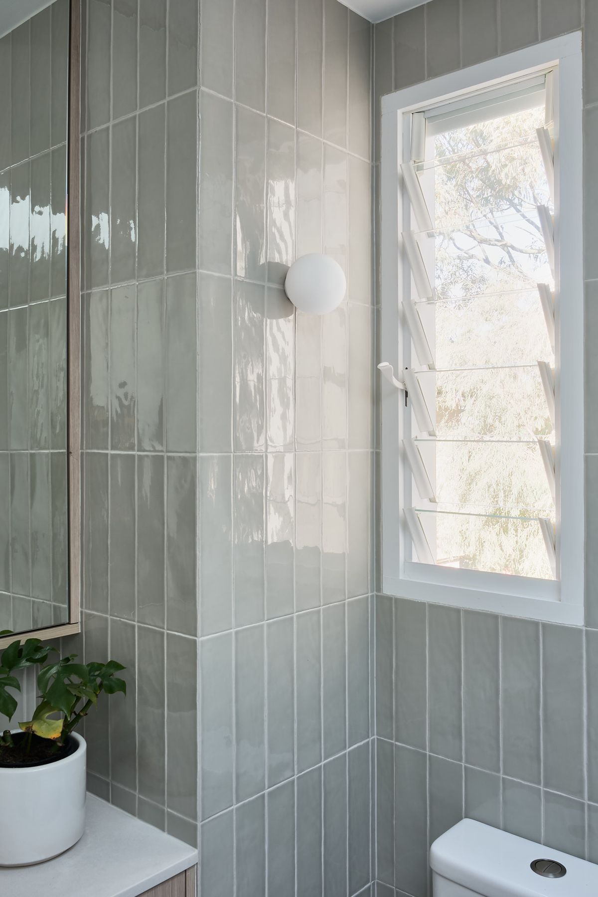 The tone enhances the natural feel connecting the interior with the tree canopy views through the windows.