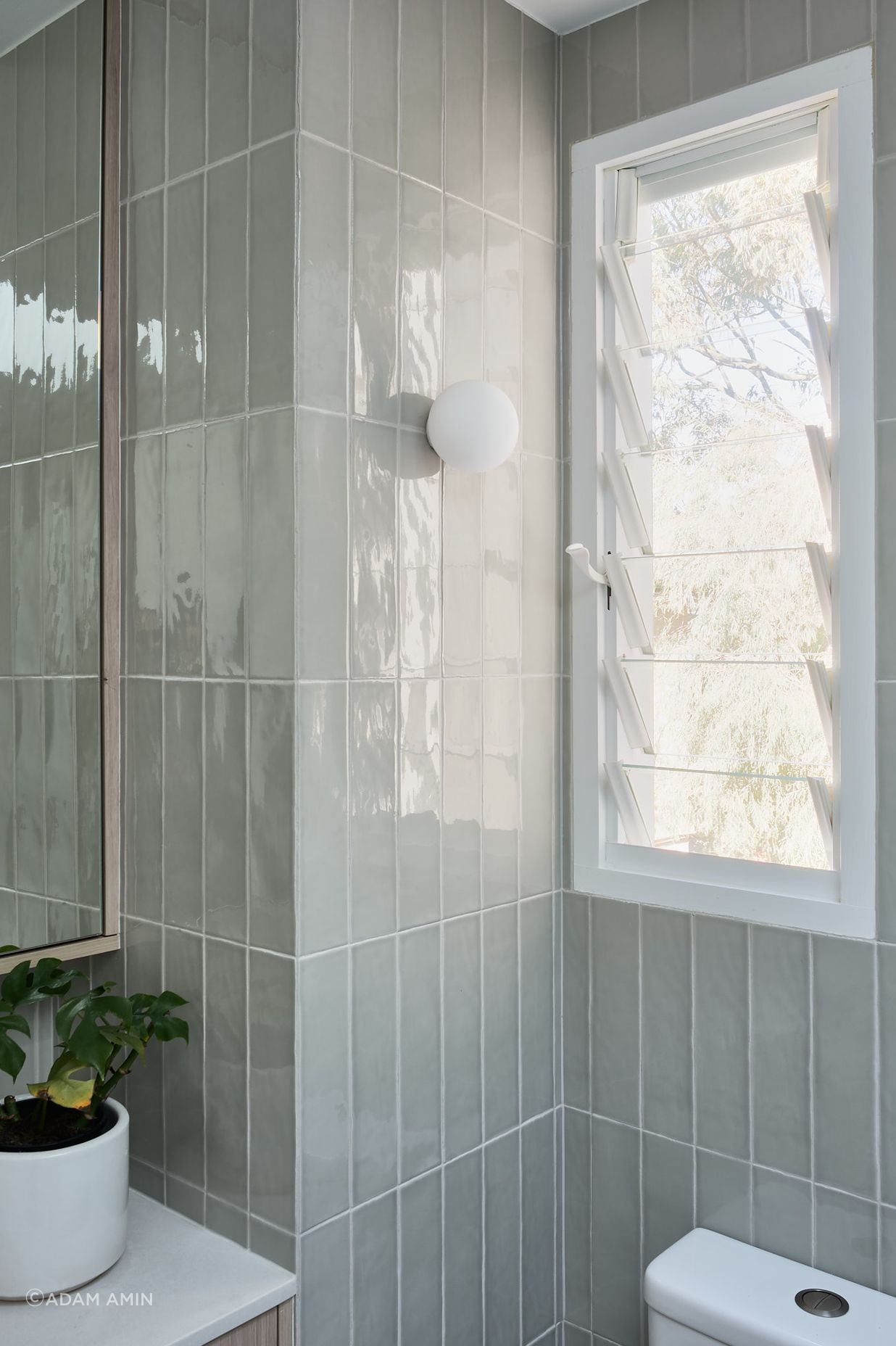 The tone enhances the natural feel connecting the interior with the tree canopy views through the windows.