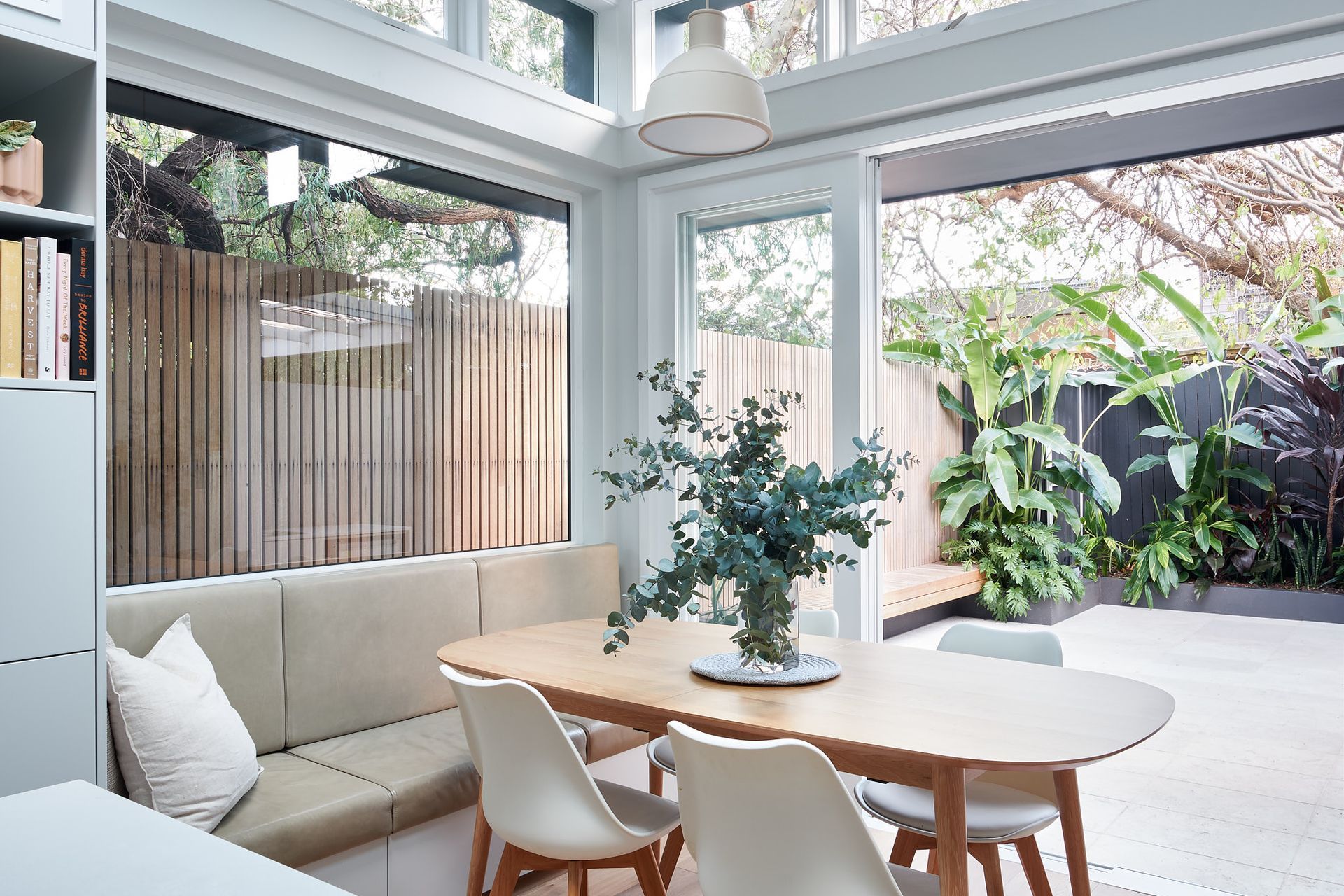 The inbuilt bench braced by the bay window above and sliding doors to the outdoor offer a casual setting for dinner with views of the surrounding vegetation.