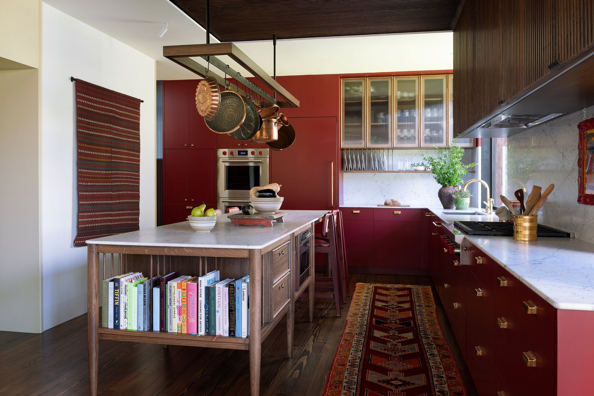 24PastandPresentPlaceCuppettKilpatrickArchitectureandInteriorDesignAustinTexaskitchen-furniture-island-fluted-wood-ribbed-glass-red-cabinets-pot-rack.jpg