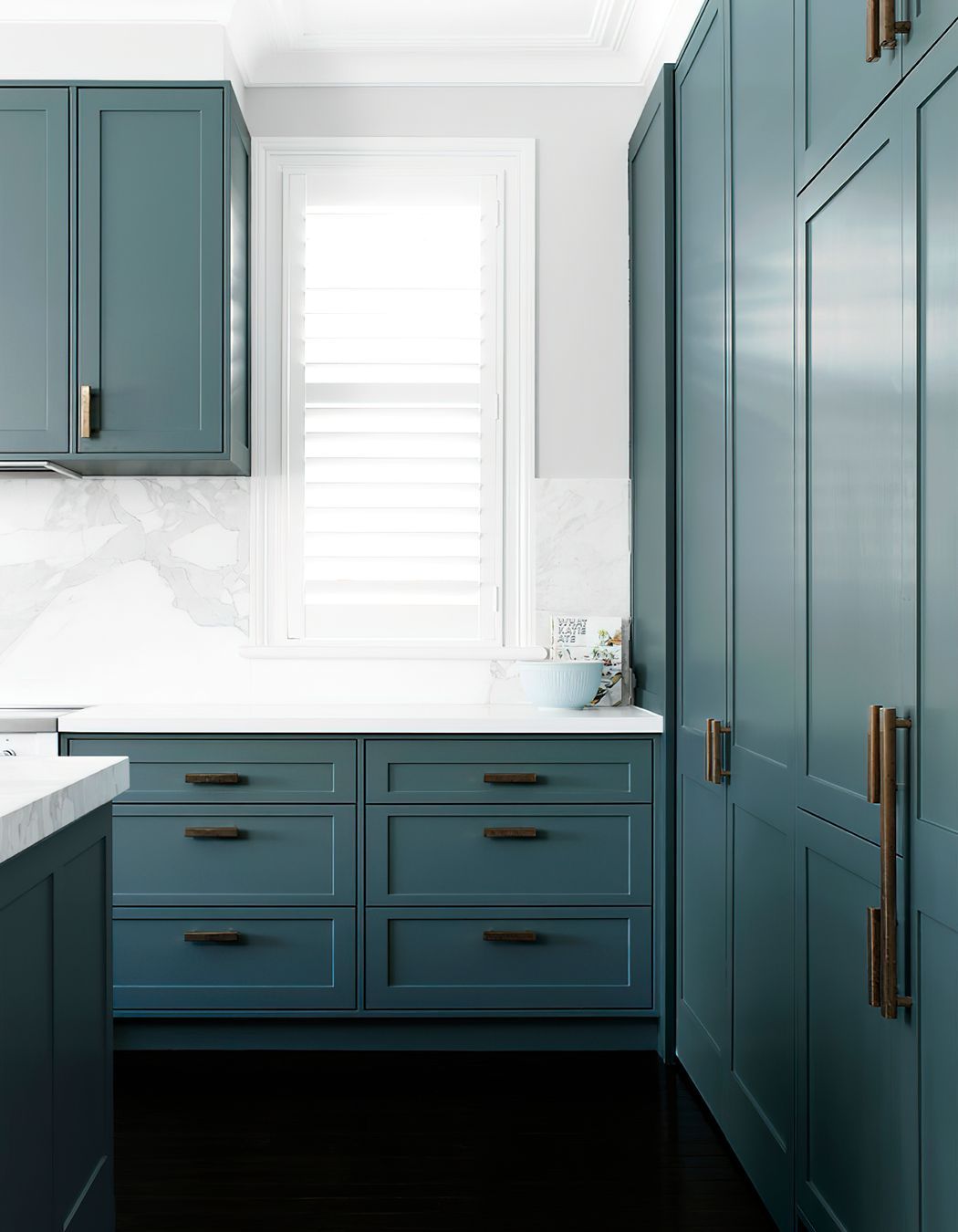 KITCHEN STORAGE - Loads of storage and extra benchspace were created in this kitchen renovation. Natural light pours through the shuttered windows.
