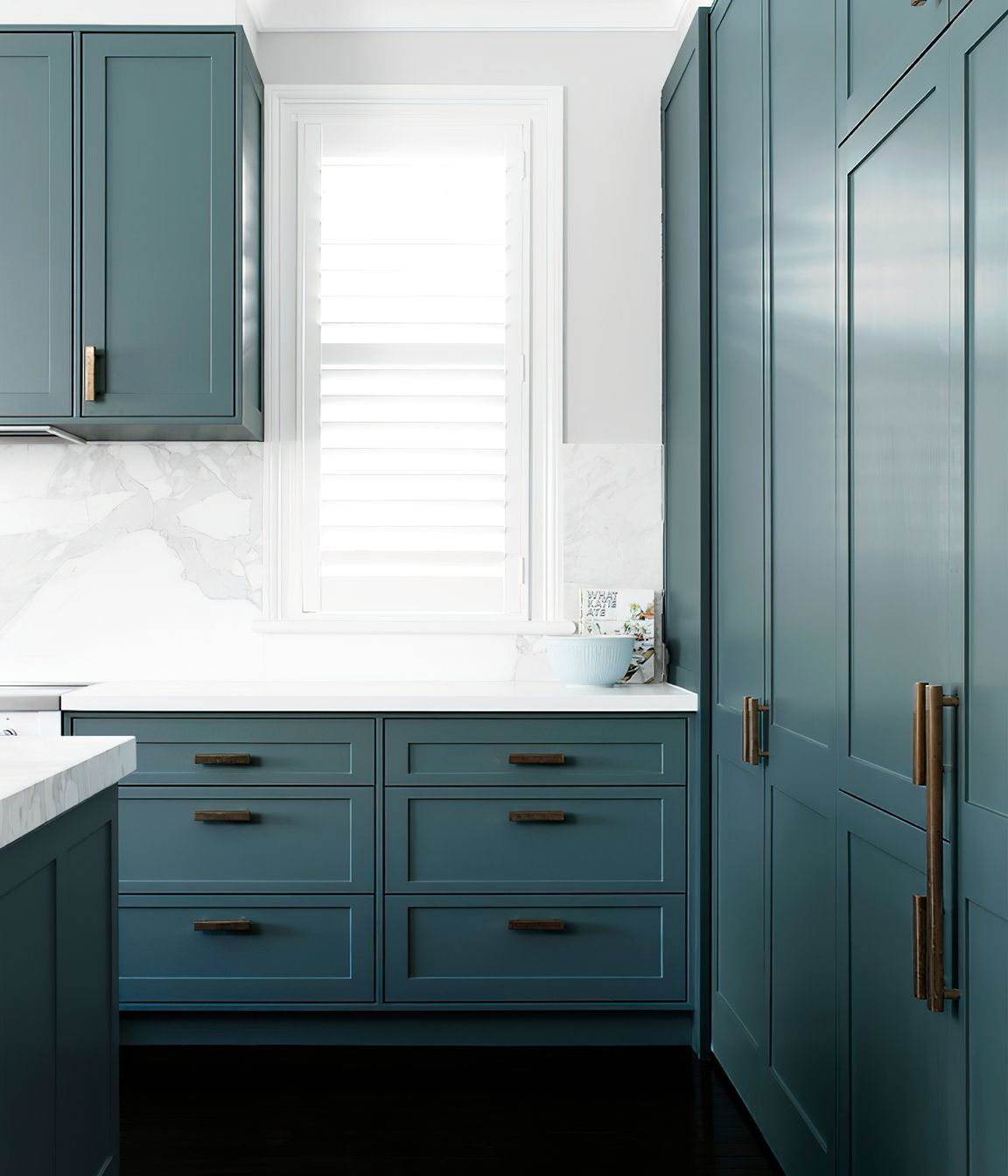KITCHEN STORAGE - Loads of storage and extra benchspace were created in this kitchen renovation. Natural light pours through the shuttered windows.