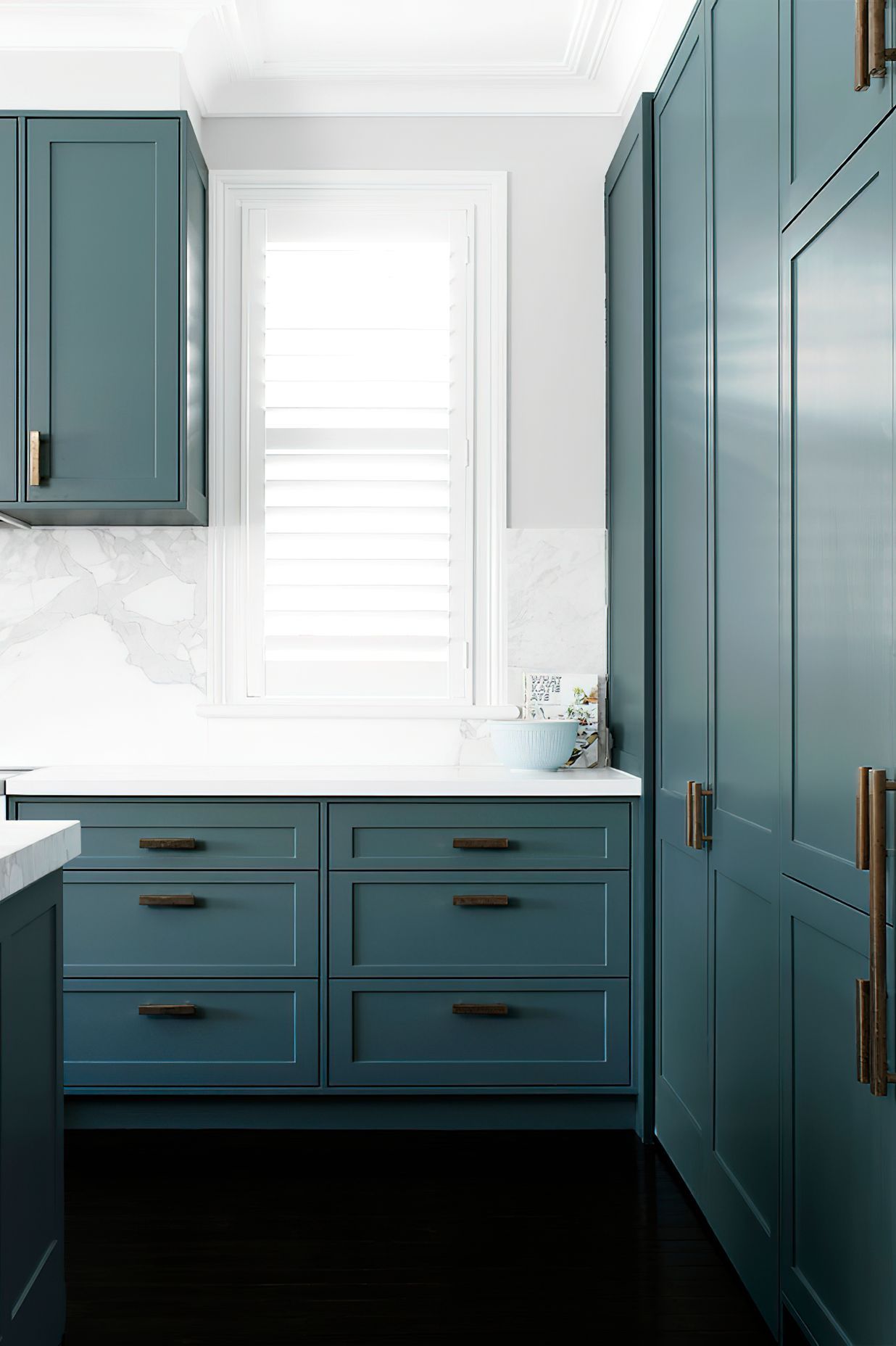 KITCHEN STORAGE - Loads of storage and extra benchspace were created in this kitchen renovation. Natural light pours through the shuttered windows.