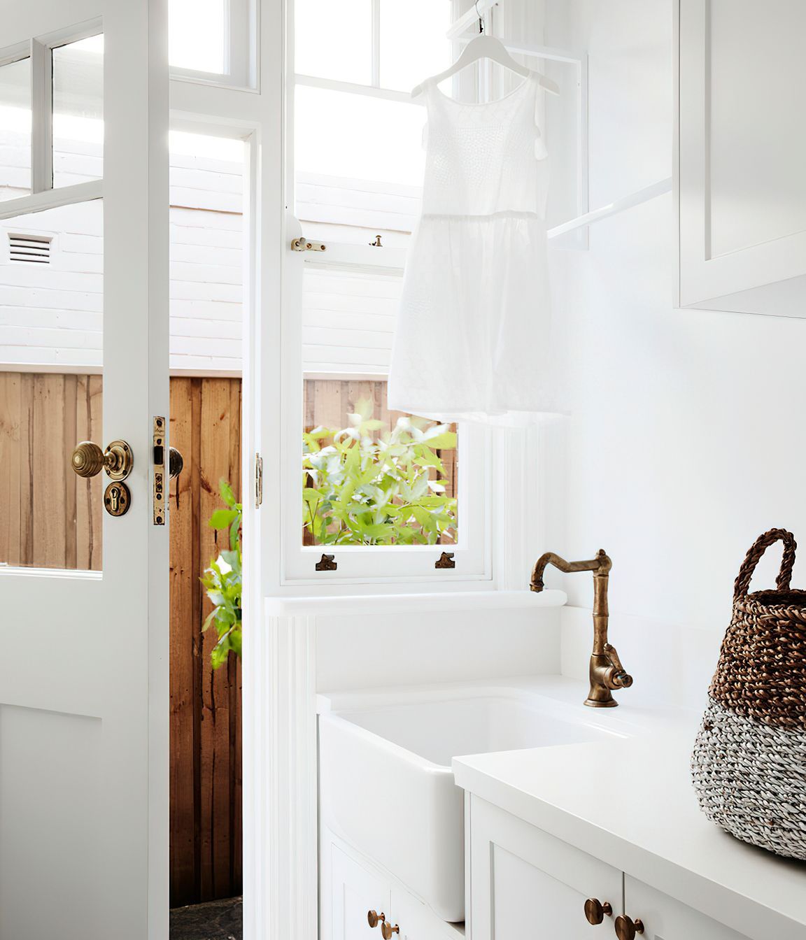 WHITE LAUNDRY - This white laundry features a butlers sink to complement the kitchen, similar tapware and mosaic tiling. It is highly functional and beautiful.