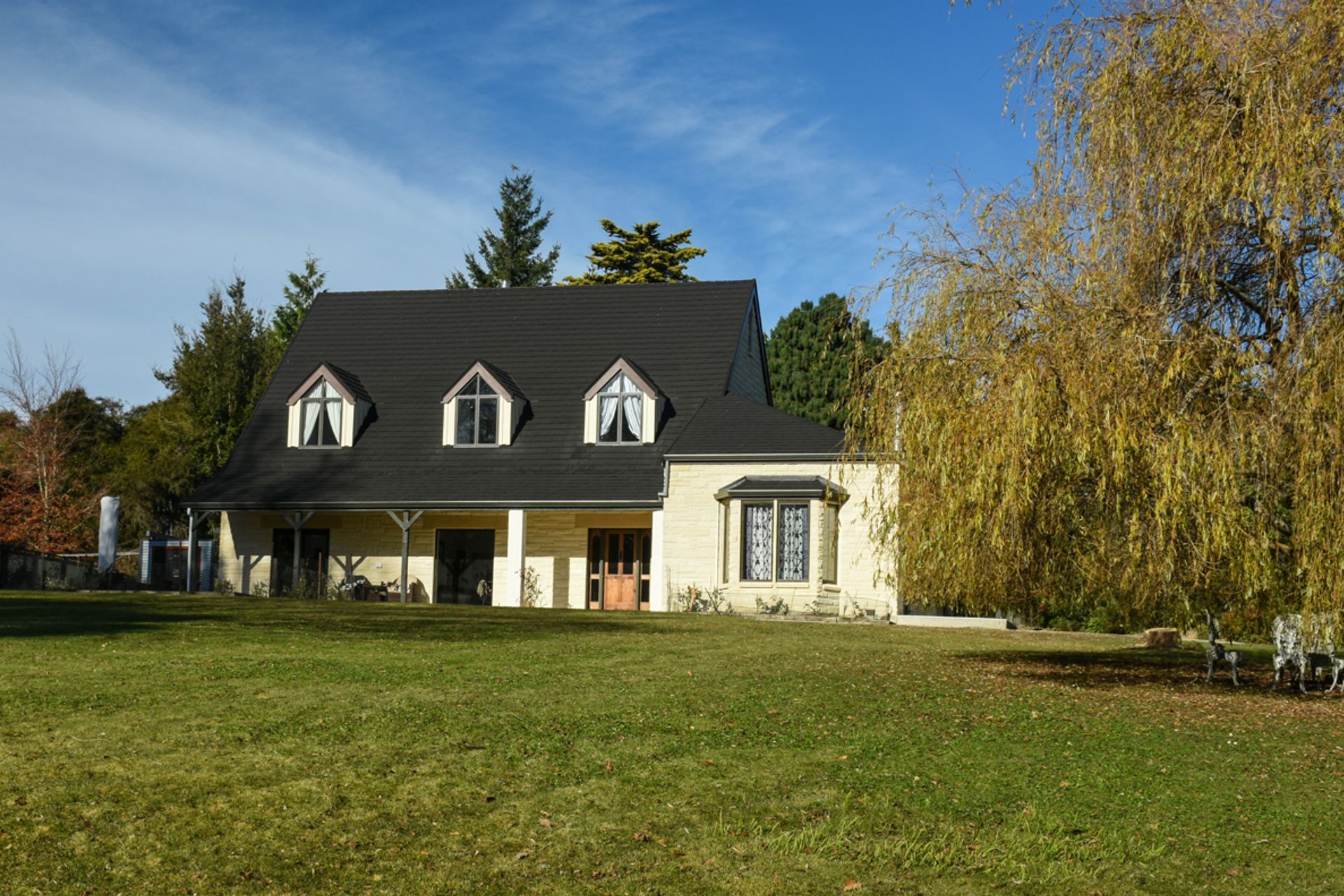 Front view - new roofing with slate alternative, double-glazed windows, bargeboards over dormer windows, restoration/cleaning of Oamaru stone along with porcelain tiles by front door entrance. View from the garden.